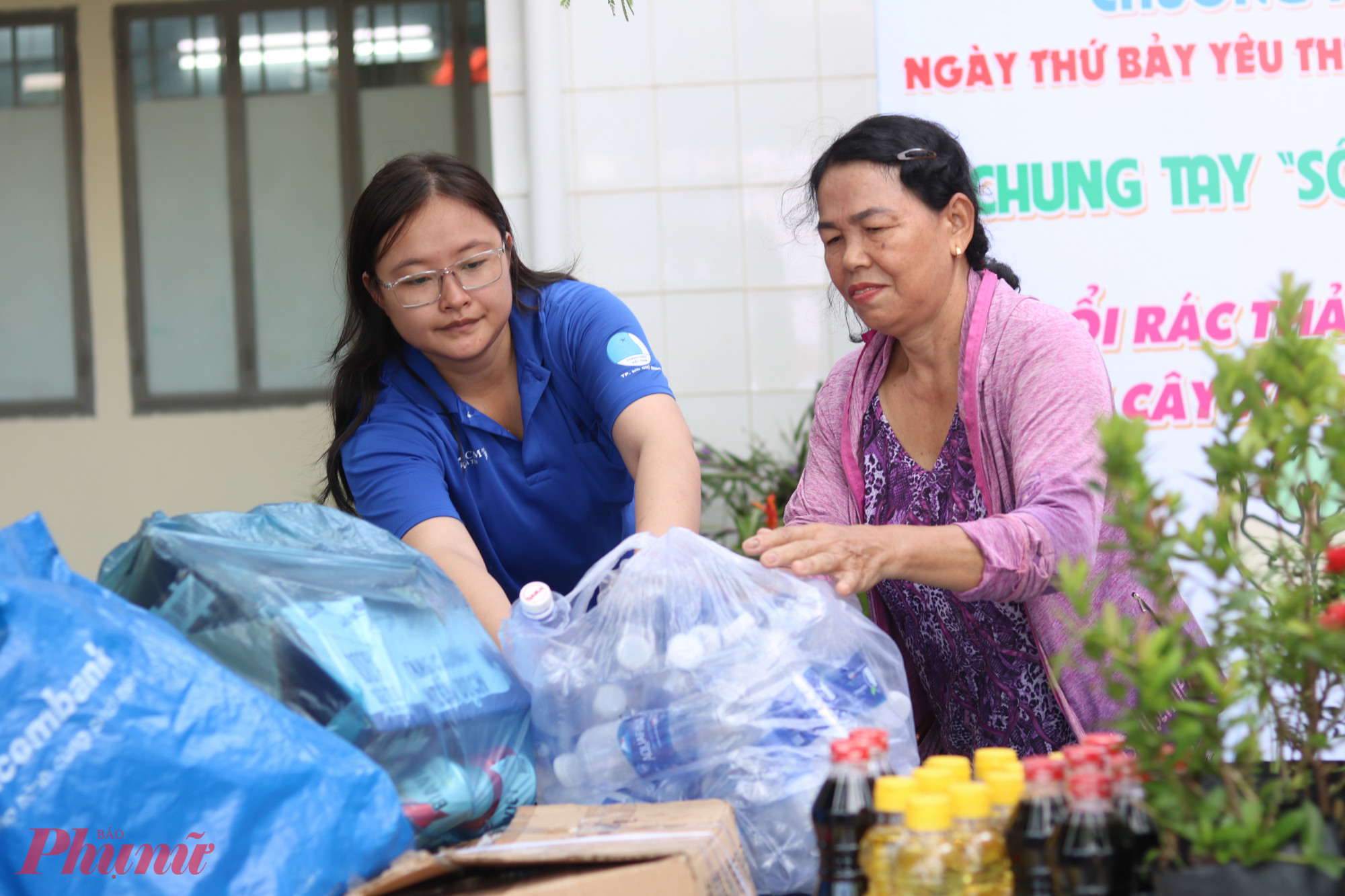 Người dân mang rác thải nhựa đến chương trình để đổi lấy cây xanh. 