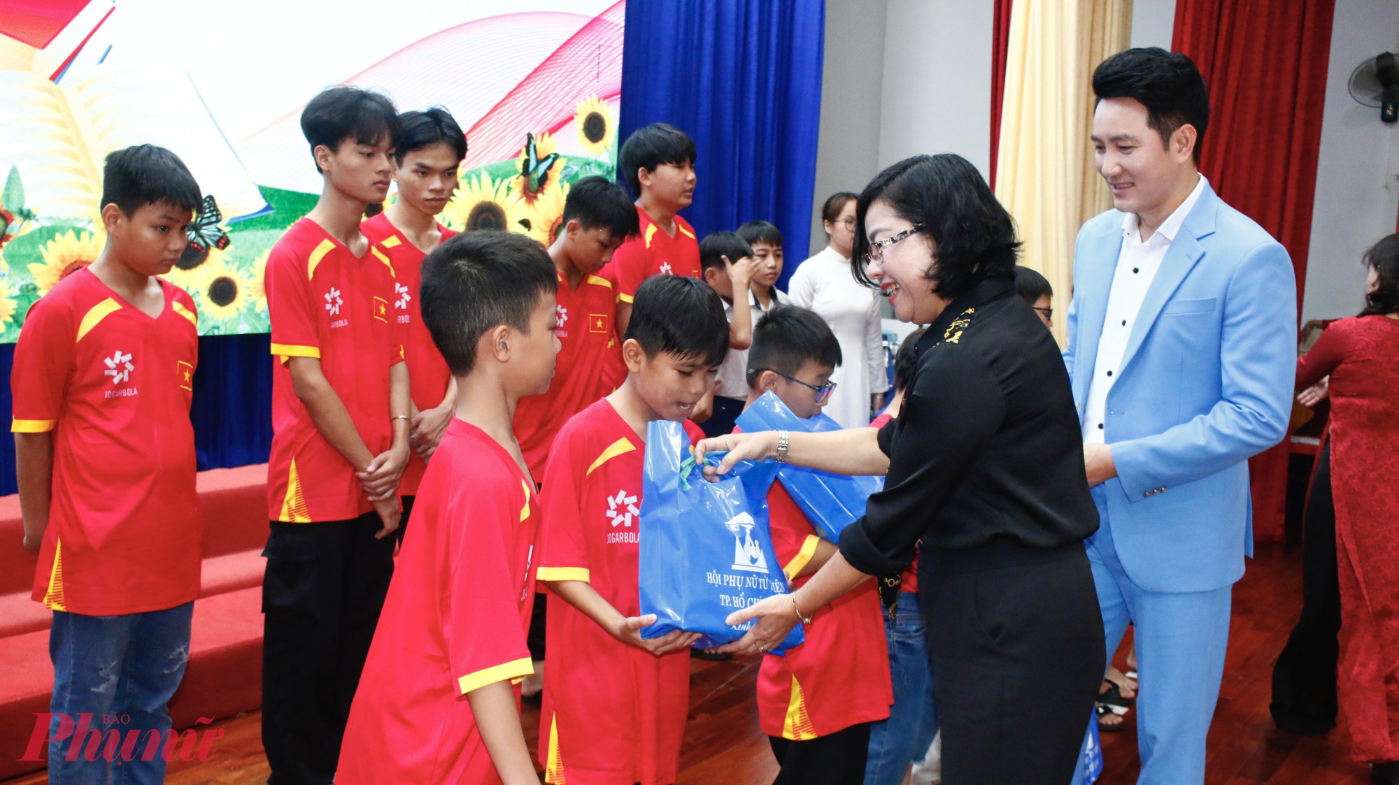 Bà Trần Hải Yến – Bí thư Đảng uỷ, Chủ tịch HĐND phường Bình Thới, TPHCM và ca sĩ Nguyễn Phi Hùng trao học bổng cho các em