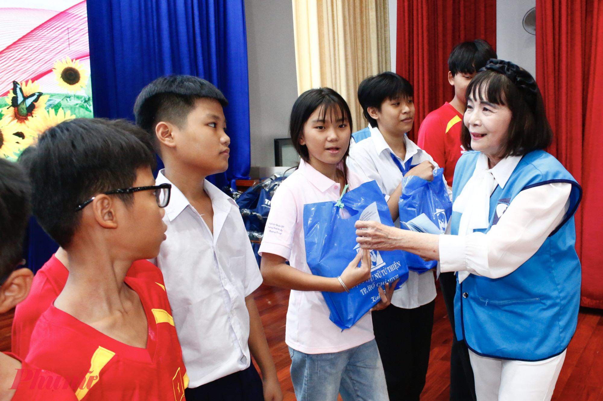 Bà Nguyễn Thị Huệ - Chủ tịch Hội Phụ nữ Từ thiện TPHCM trao học bổng đến các em