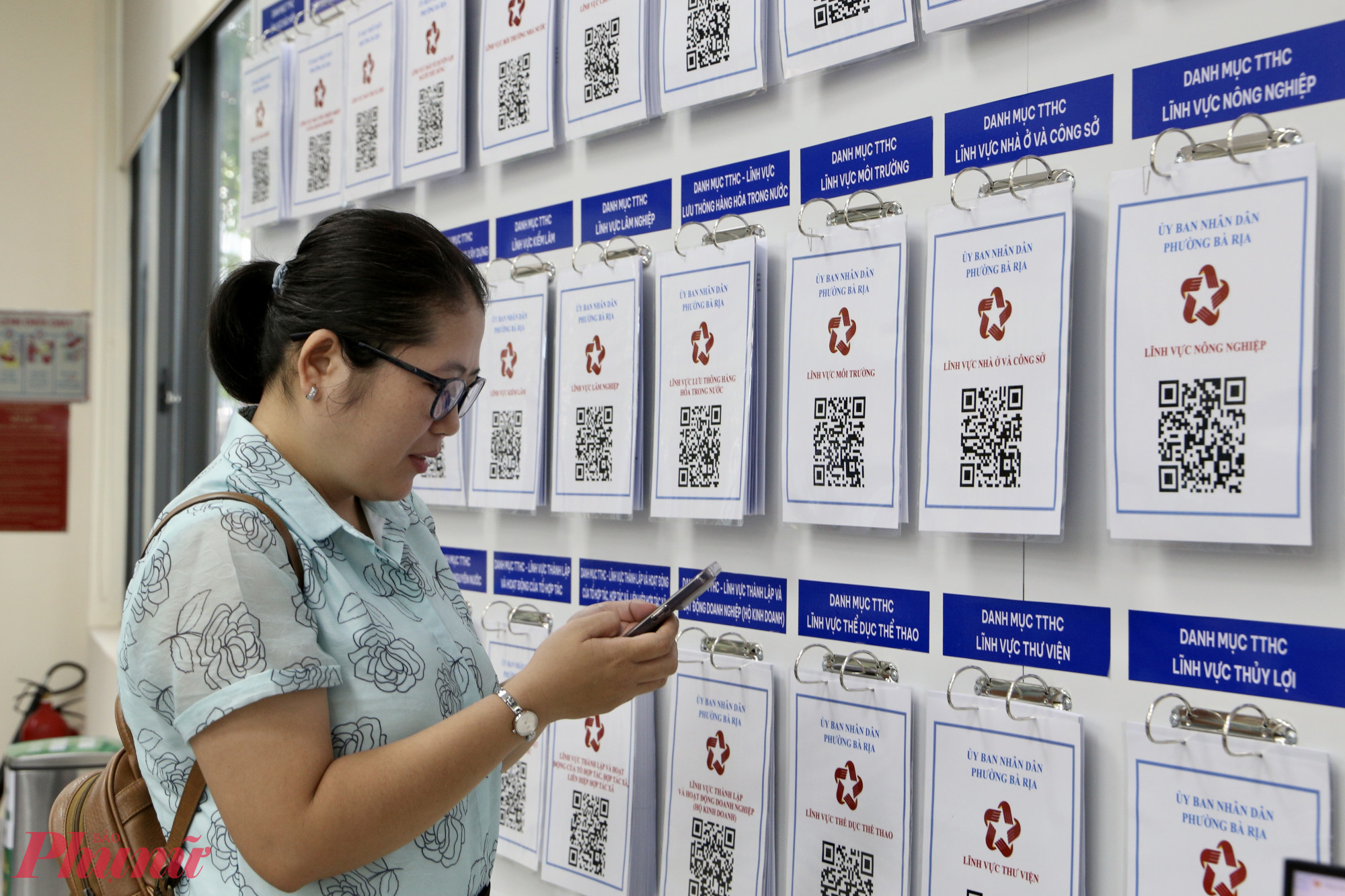 Người dân có thể sử dụng điện thoại thông minh, quét mã QR được niêm yết tại Trung tâm để tra cứu thông tin, giải quyết thủ tục hành chính nhanh gọn - Ảnh: Thanh Tâm