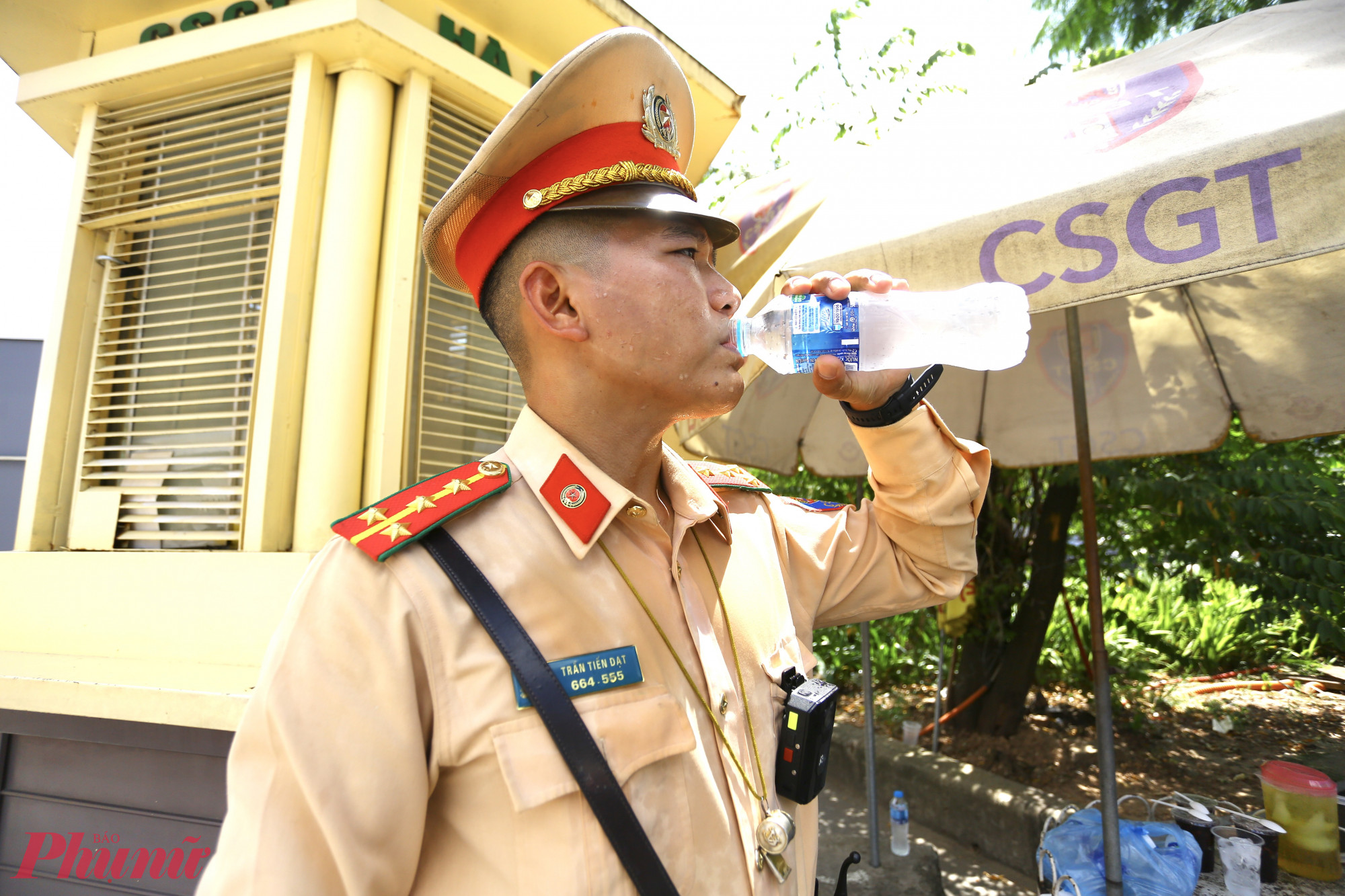 Mồ hôi ướt đẫm vì nắng nóng, CSGT Hà Nội liên tục phải sử dụng nước để hạ nhiệt.