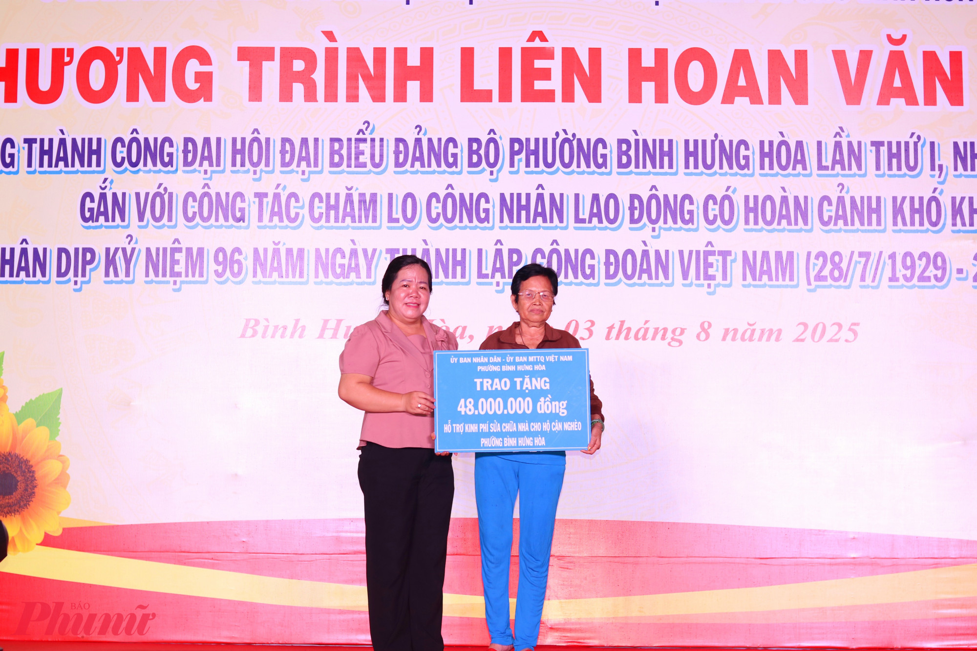 Bà Nguyễn Thanh Nguyệt – Chủ tịch Ủy ban Mặt trận Tổ quốc phường Bình Hưng Hoà – trao bảng tượng trưng kinh phí hỗ trợ gia đình bà Nguyễn Thị Tâm sửa nhà. 