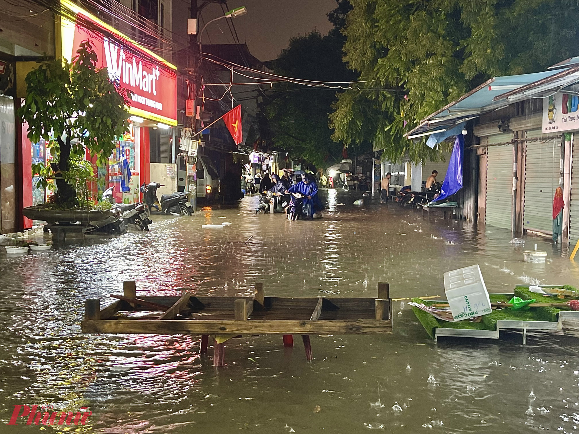 Người dân dùng ghế, tấm gỗ,... chắn cảnh báo điểm ngập, hạn chế các phương tiện đi vào vùng nước sâu.