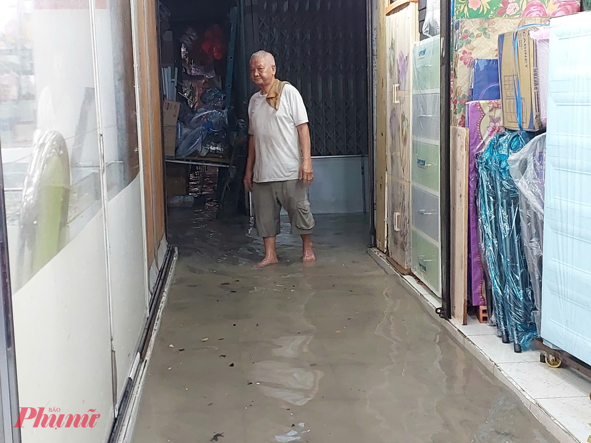 Nước tràn vào các kiot trong chợ khiến việc buôn bán của tiểu thương gặp khó khăn.