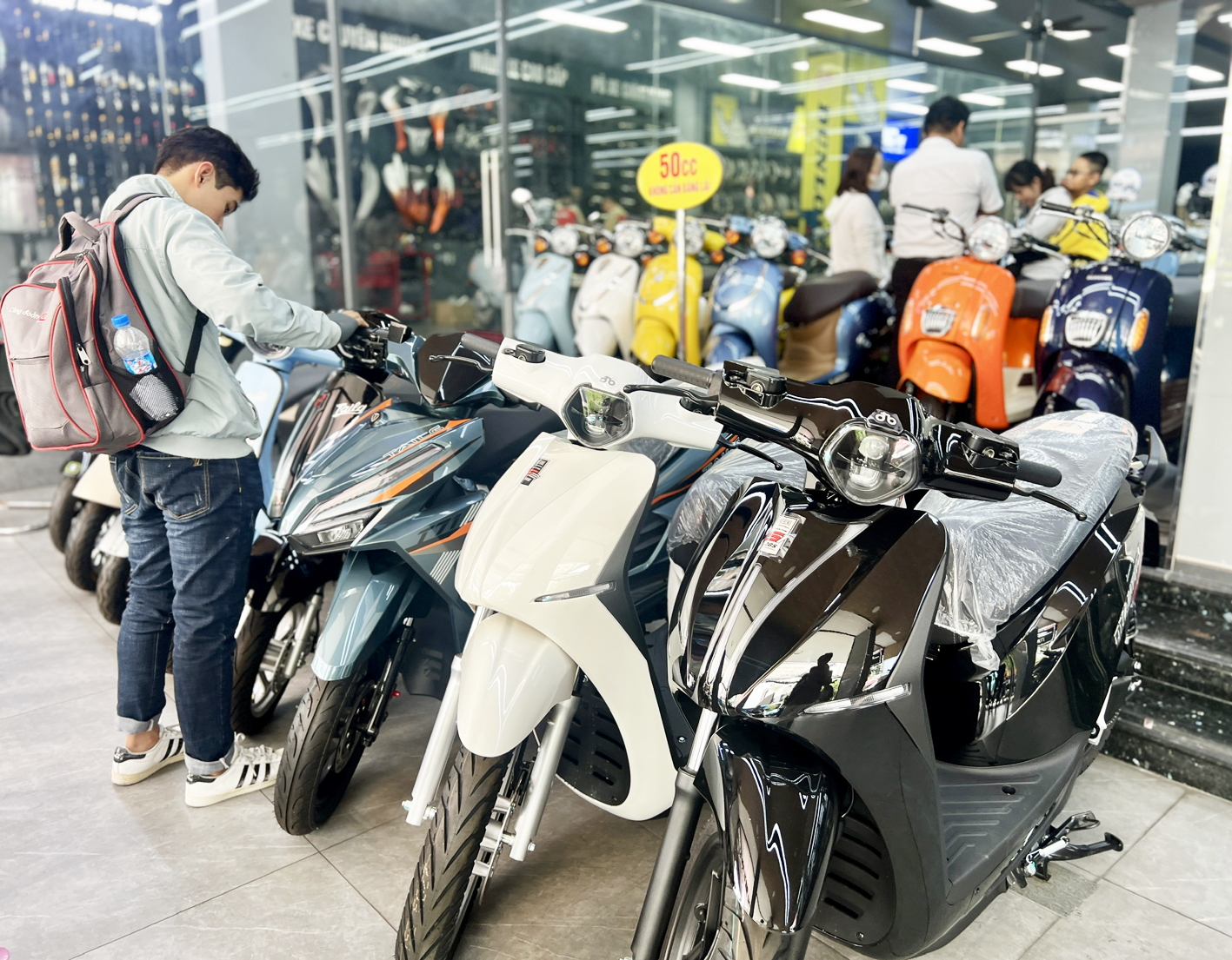 Người dân đến tìm hiểu về các mẫu xe máy điện tại một cửa hàng trên đường Xô Viết Nghệ Tĩnh, phường Gia Định, TPHCM, hôm 25/7