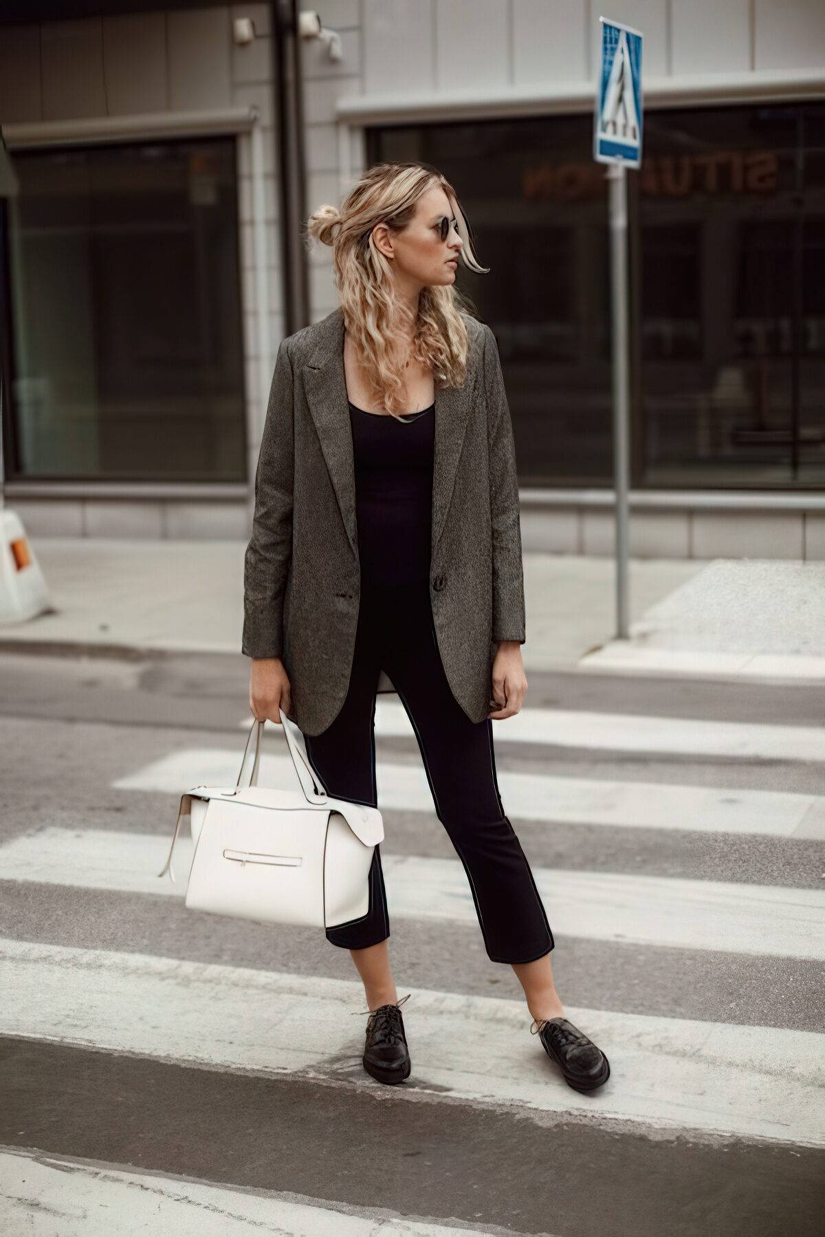 Outfit này mang đến vẻ ngoài trẻ trung và cá tính với phong cách smart-casual hiện đại. Áo blazer xám dáng oversized phối cùng áo thun đen và quần lửng tôn dáng, kết hợp đôi giày Derby tạo nên sự cân bằng giữa thoải mái và chuyên nghiệp. 