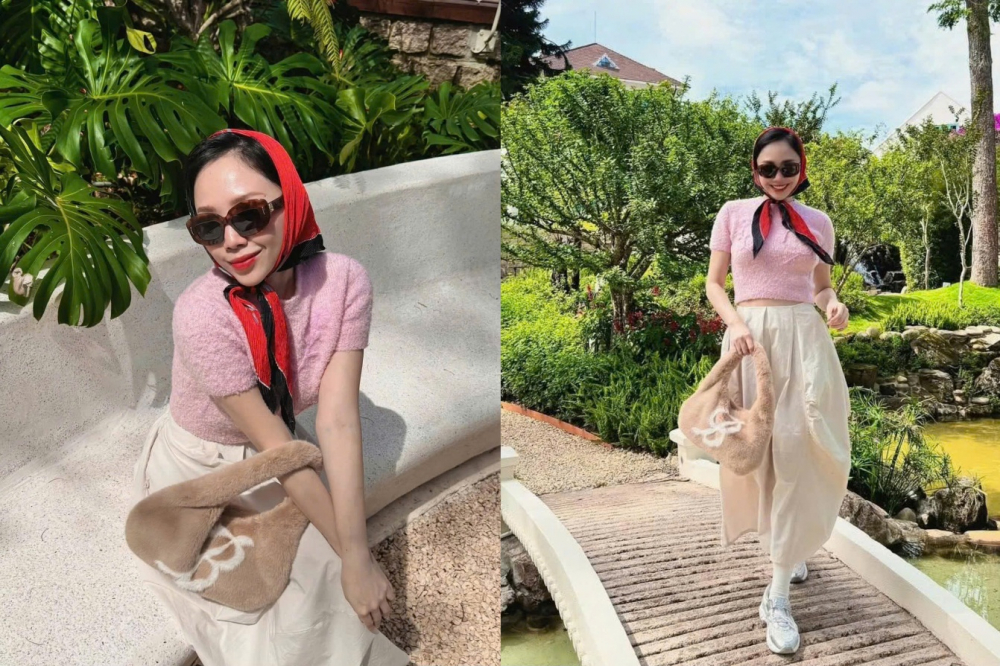 Công thức 4: Hồng + Trắng + Đỏ Với outfit mang sắc hồng phấn nhẹ như bọt sữa, nữ ca sĩ Tóc Tiên gợi nhớ đến hình ảnh những quý cô thập niên 50 vừa ngọt ngào vừa đầy khí chất. Chiếc khăn turban đỏ rực buộc hờ quanh cổ tạo điểm nhấn rực rỡ giữa bảng màu pastel, khiến tổng thể không bị “chìm” trong sự dịu dàng. Chân váy trắng kem bung nhẹ trong nắng, chất vải hơi bóng tạo hiệu ứng “bay bổng” mỗi khi di chuyển. Đây là cách chơi màu thông minh  khi sắc đỏ được dùng làm phần nổi, nhấn nhá cho cả một bản phối ngọt như kẹo.