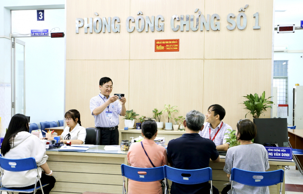 Công chứng viên Phòng công chứng số 1 chụp ảnh khi người dân ký văn bản 