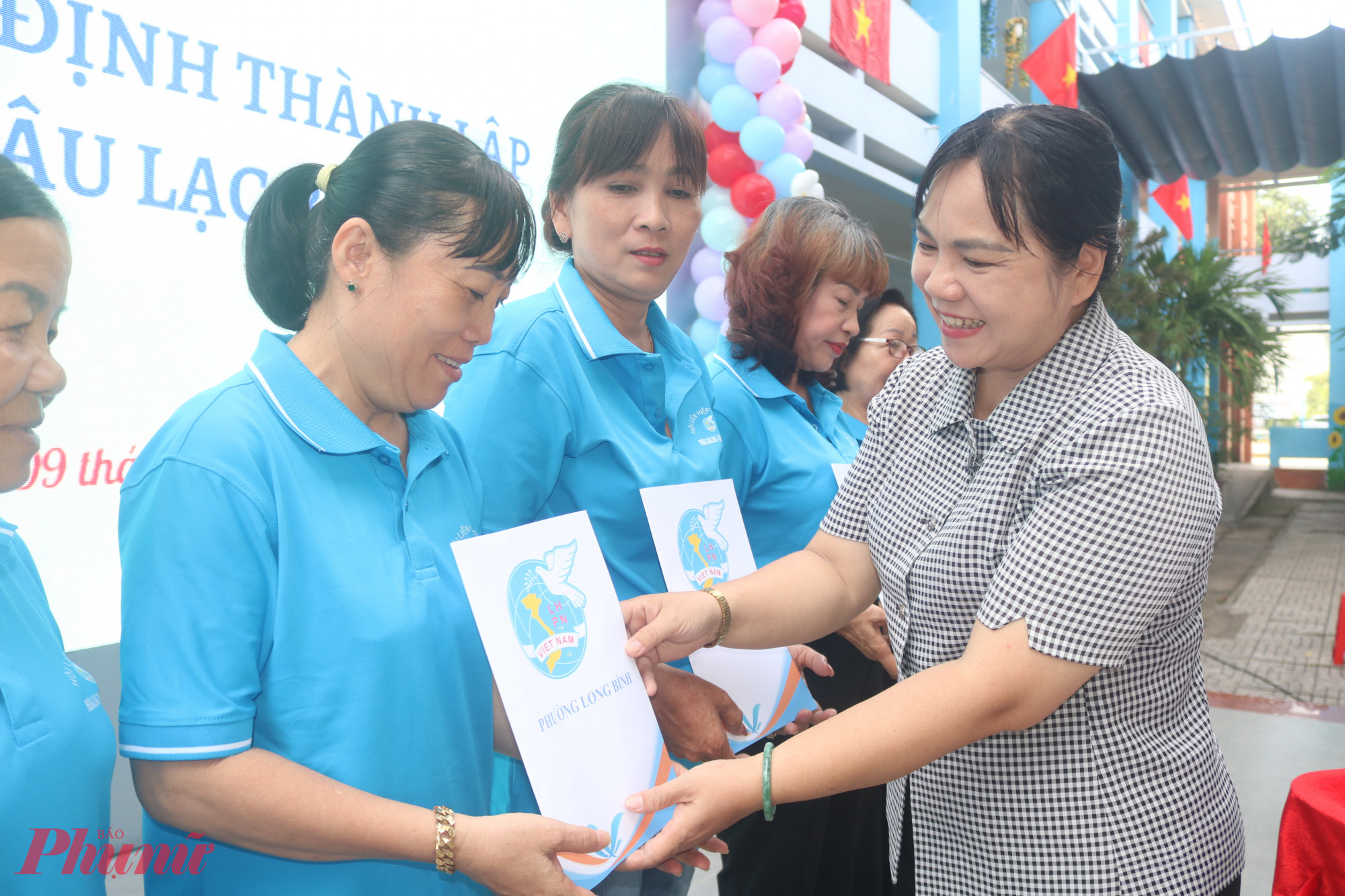 Bà Nguyễn Hạnh Thảo – Phó bí thư thường trực Đảng ủy phường Long Bình, TPHCM – trao quyết định chỉ định chi hội trưởng phụ nữ khu phố cho các dì, các chị - Ảnh: Mẫn Nhi