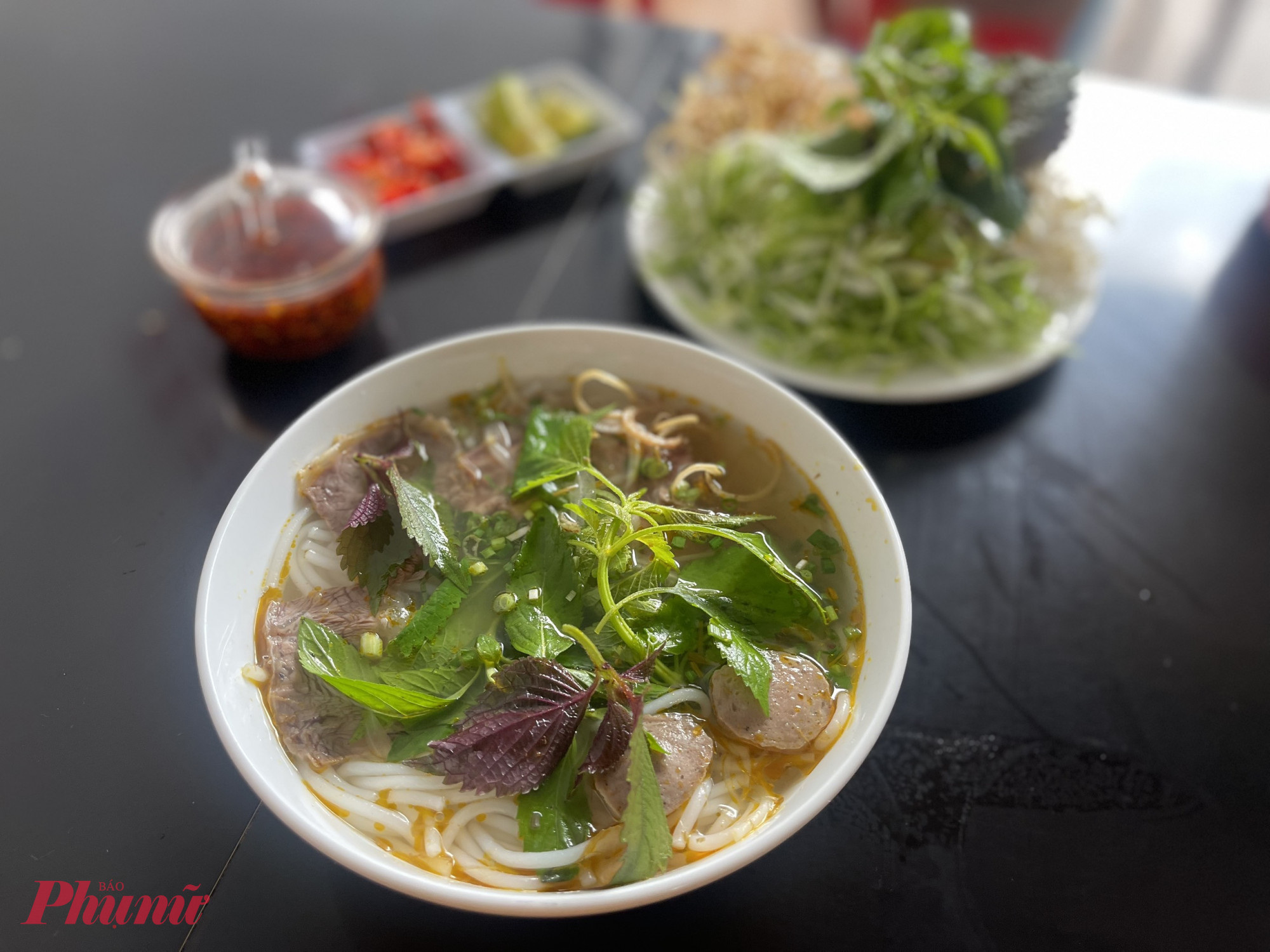 Không giống vị đậm đà, cay nồng của bún bò Huế, bún bò tại TP Bảo Lộc mang bản sắc riêng với nước dùng thanh nhẹ, ngọt tự nhiên từ xương hầm, ít dầu mỡ, dễ ăn và hợp khẩu vị nhiều người. Một điểm nhấn không thể thiếu là đĩa rau sống đặc trưng gồm xà lách, bắp cải bào mỏng, rau thơm tươi xanh – tất cả tạo nên sự hài hòa giữa vị béo, ngọt và tươi mát trong từng tô bún.