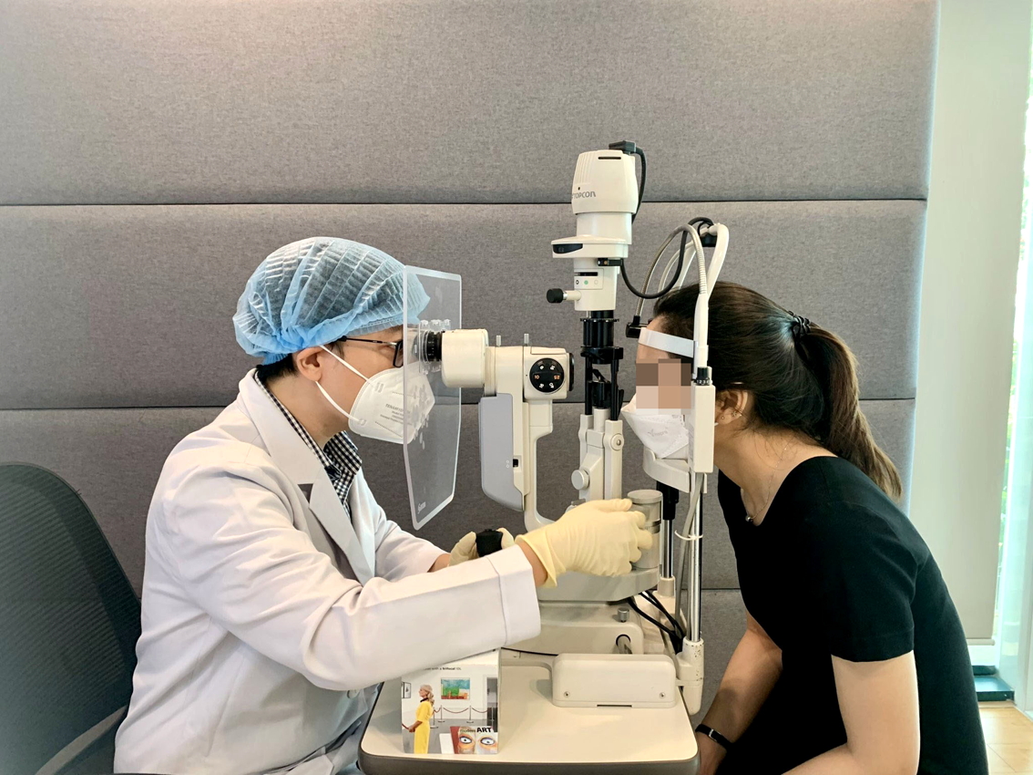 Bác sĩ Trần Đình Minh Huy đang kiểm tra thị lực cho trường hợp trẻ tuổi bị đục thủy tinh thể - ẢNH: Đ.H.