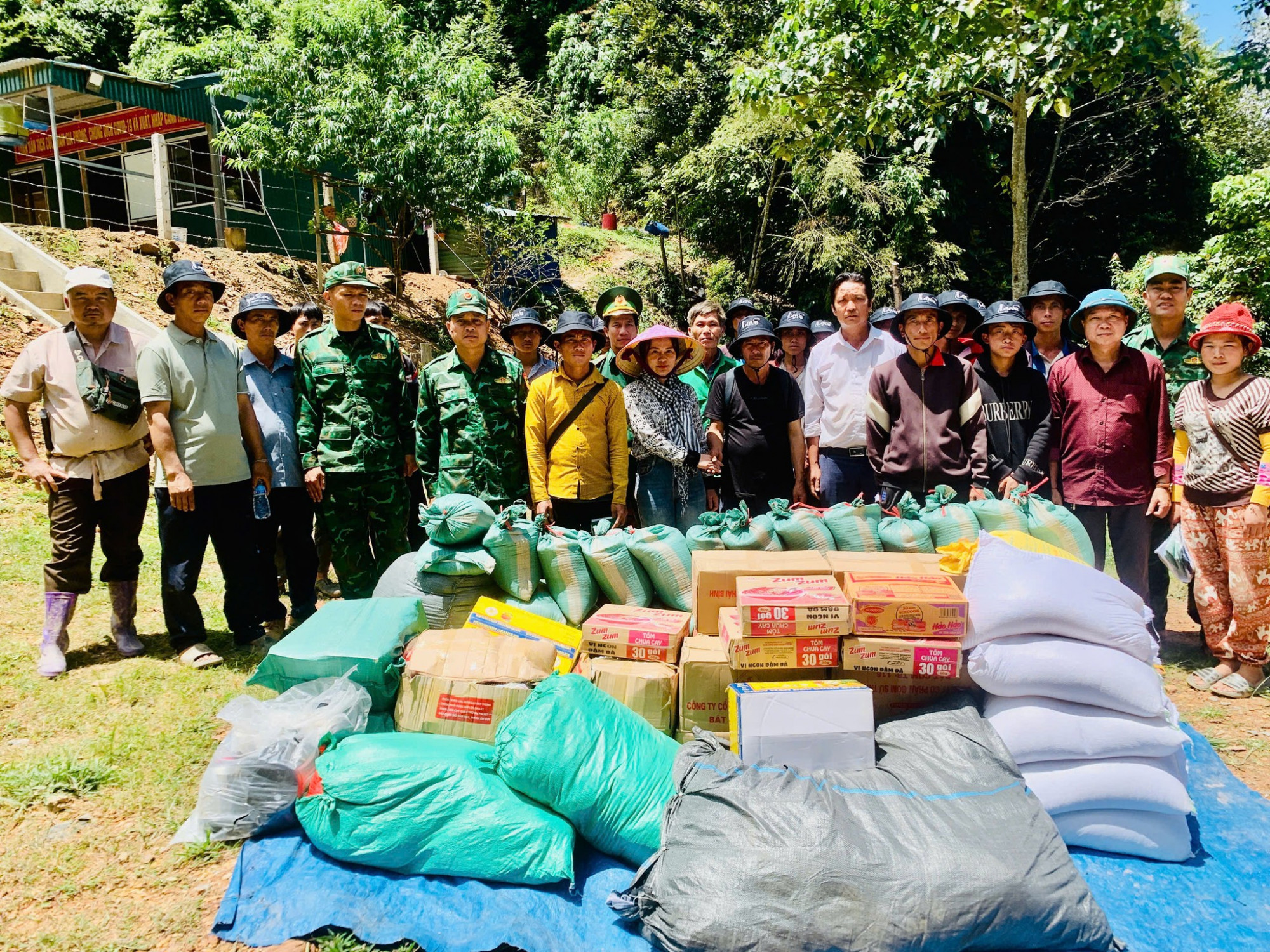 Các lực lượng chức năng xã Mường Típ trao hàng cứu trợ cho người dân cụm bản Xám Chè - Ảnh: Khánh Trung