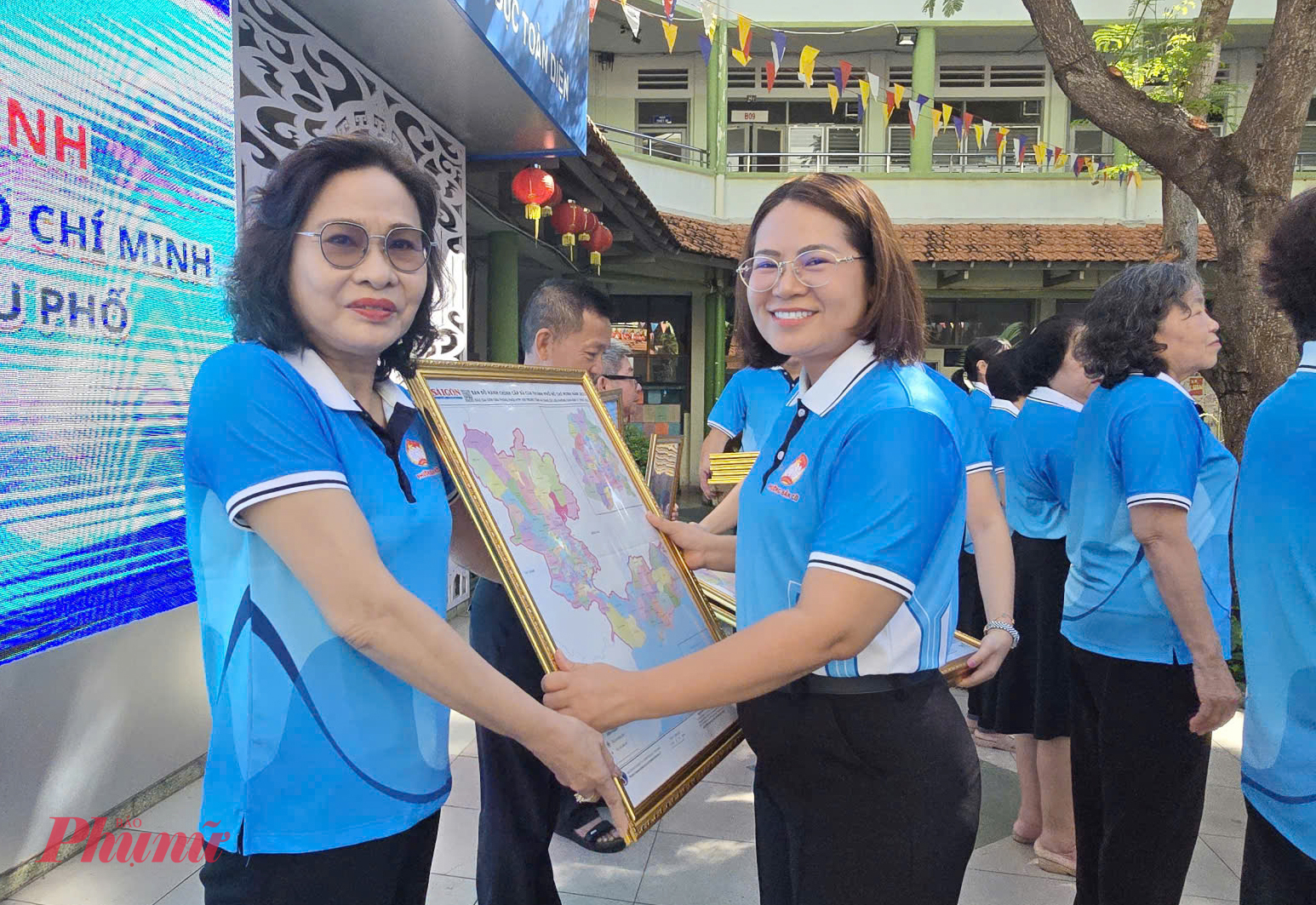 Bà Đoàn Thị Cẩm Tú - Chủ tịch Ủy ban MTTQ Việt Nam phường - trao tặng bản đồ hành chính TPHCM cho 36 khu phố