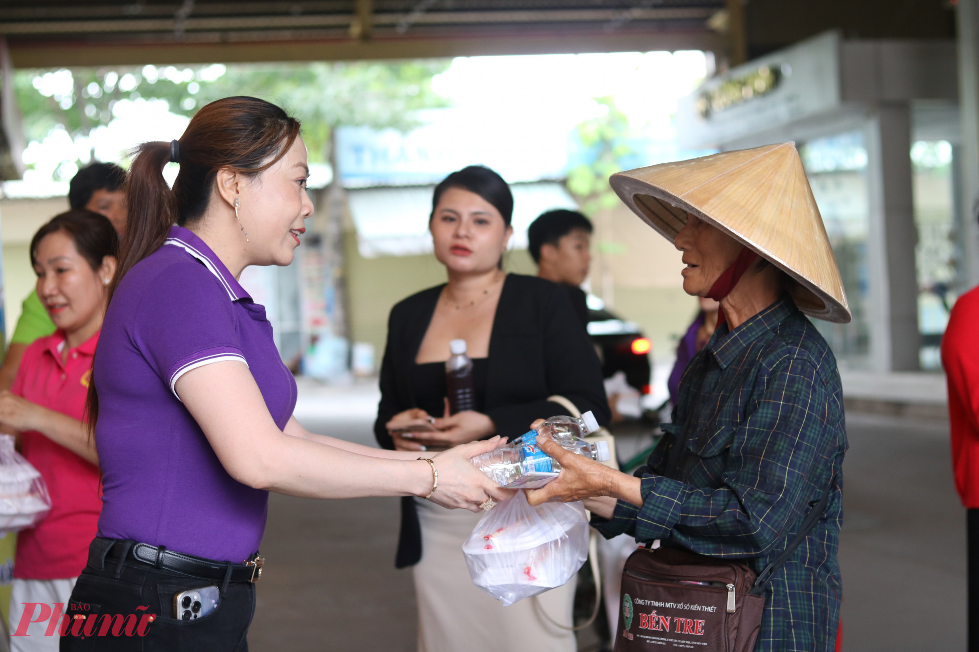 Chị Phạm Thị Út – Chi hội trưởng Chi hội Phụ nữ khu phố 11, phường Bình Tân, TPHCM (bìa trái) – trao hộp bún xào và nước uống cho cô Nguyễn Thị Hường, người bán vé số dạo trên địa bàn - Ảnh: Mẫn Nhi