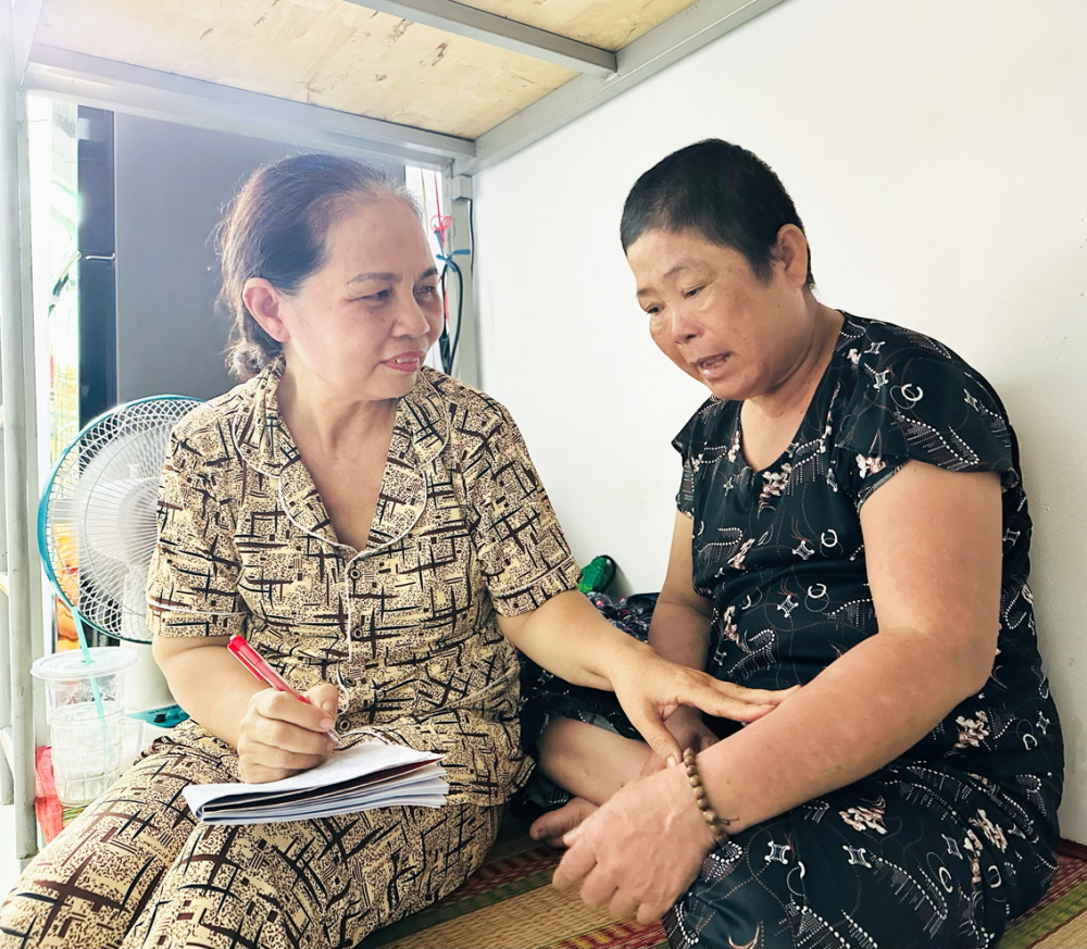 Bà Tạ Thị Nhạn (bìa trái) - người thành lập và quản lý Mái ấm 0 đồng  - hỏi thăm, ghi chú lại tình trạng sức khỏe của bệnh nhân tại mái ấm