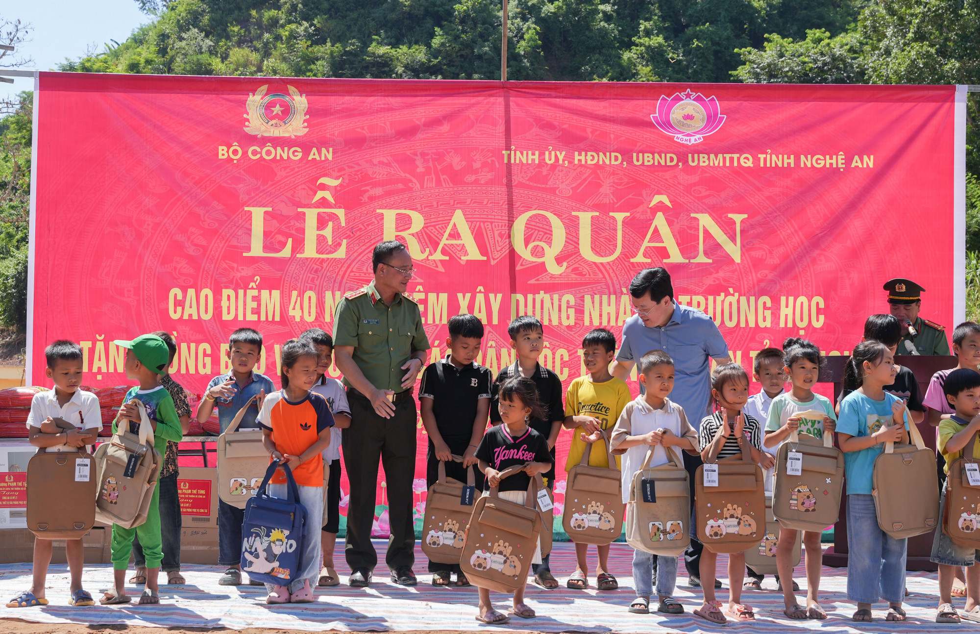 Thượng tướng Phạm Thế Tùng và lãnh đạo tỉnh Nghệ An tặng quà động viên các cháu học sinh xã Mỹ Lý - Ảnh: Khánh Trung