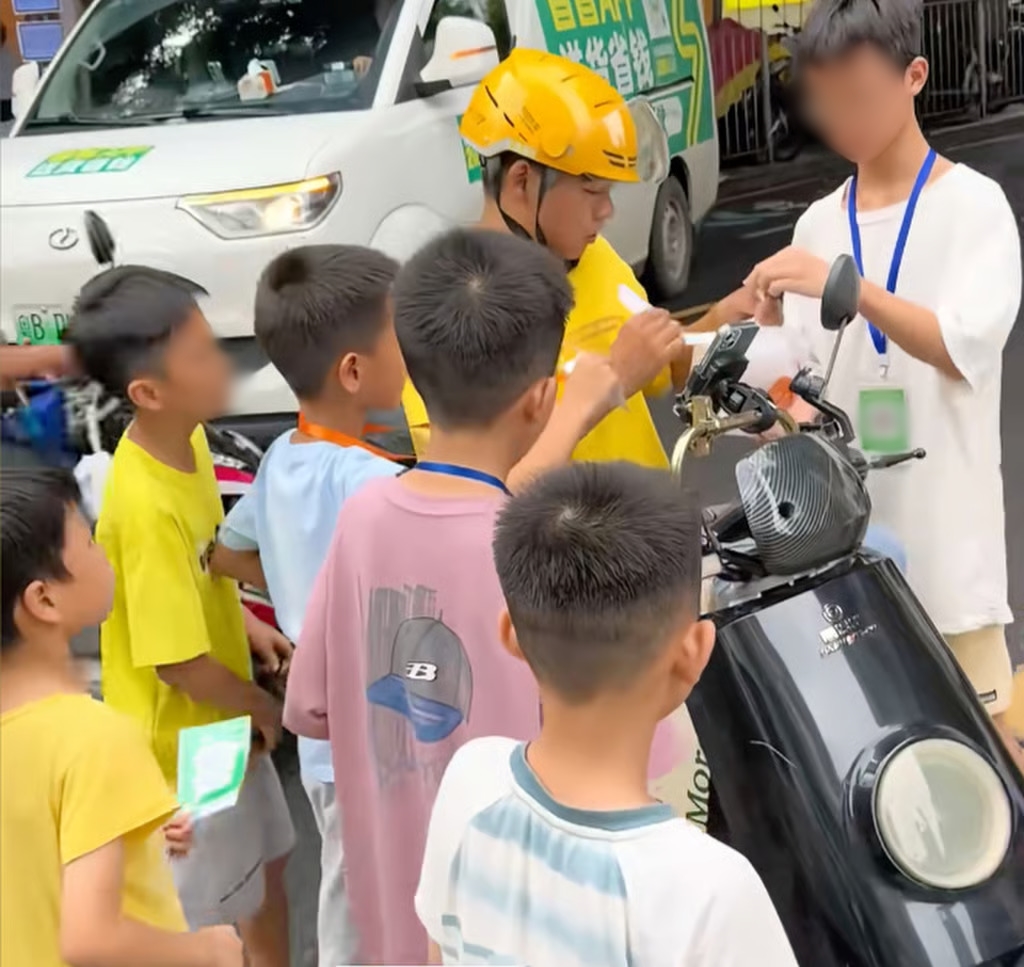 Nhóm trẻ em tranh nhau nhận đơn hàng từ shipper để nhận được 2 tệ cho mỗi lần giao đồ ăn thành công - Ảnh: hanout