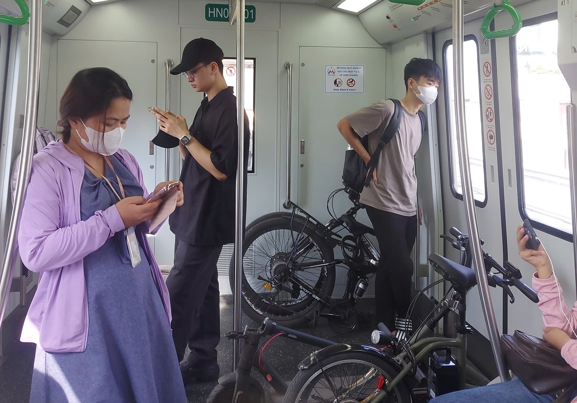 Người dân mang xe điện lên tàu điện Metro - ảnh: H.Anh
