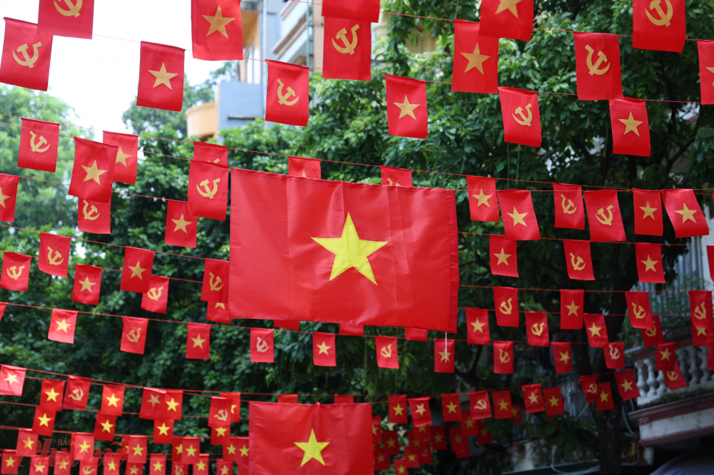 Hàng nghìn lá cờ mini được treo cao, xếp thành dải dài như tấm thảm đỏ bay trên cao, dẫn lối du khách khám phá phố cổ.
