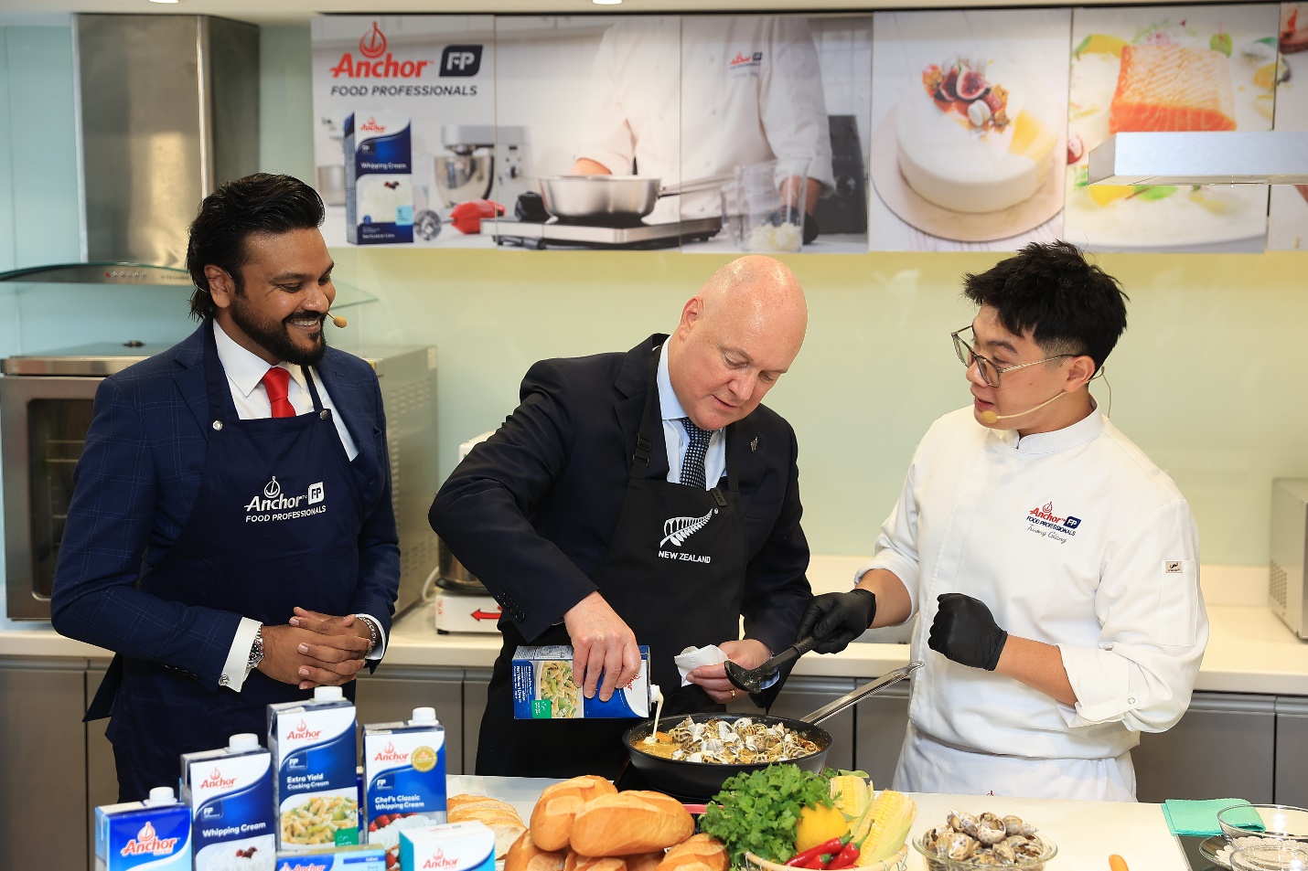 Thủ tướng New Zealand Christopher Luxon cùng cố vấn kỹ thuật ẩm thực của Anchor Food Professionals chế biến món ăn độc đáo mang hương vị Việt Nam kết hợp cùng bơ và kem sữa nấu - Ảnh: Fonterra Brands Việt Nam