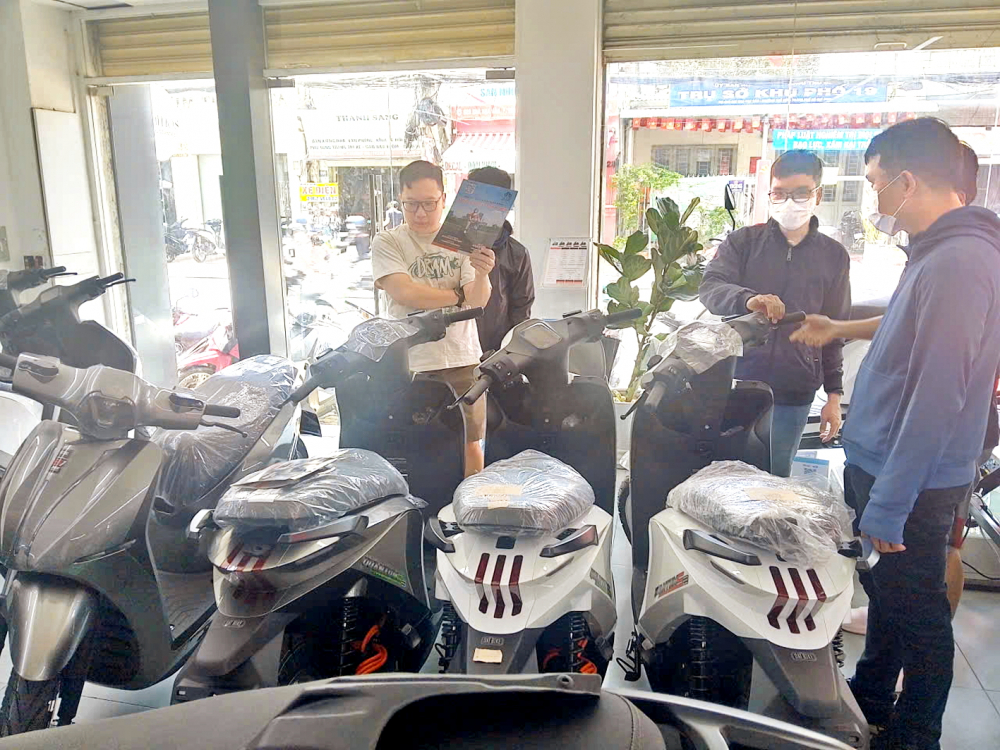 Nhiều người dân đến tìm hiểu, mua xe máy điện tại một cửa hàng trên đường Kha Vạn Cân, phường Thủ Đức, TPHCM sau khi TPHCM có kế hoạch hạn chế xe xăng vào khu vực trung tâm - Ảnh: Đăng Thư