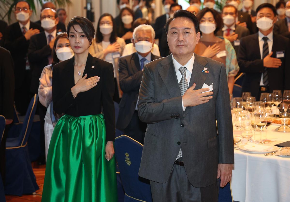 Cựu Tổng thống Yoon Suk Yeol và cựu đệ nhất phu nhân Kim Keon Hee chào quốc kỳ trong một buổi gặp mặt ăn tối với cư dân Hàn Quốc tại Madrid, Tây Ban Nha, ngày 29 tháng 6 năm 2022. Bà Kim đang đeo chiếc vòng cổ Van Cleef & Arpels ở trung tâm của cuộc tranh cãi - Ảnh: Yonhap