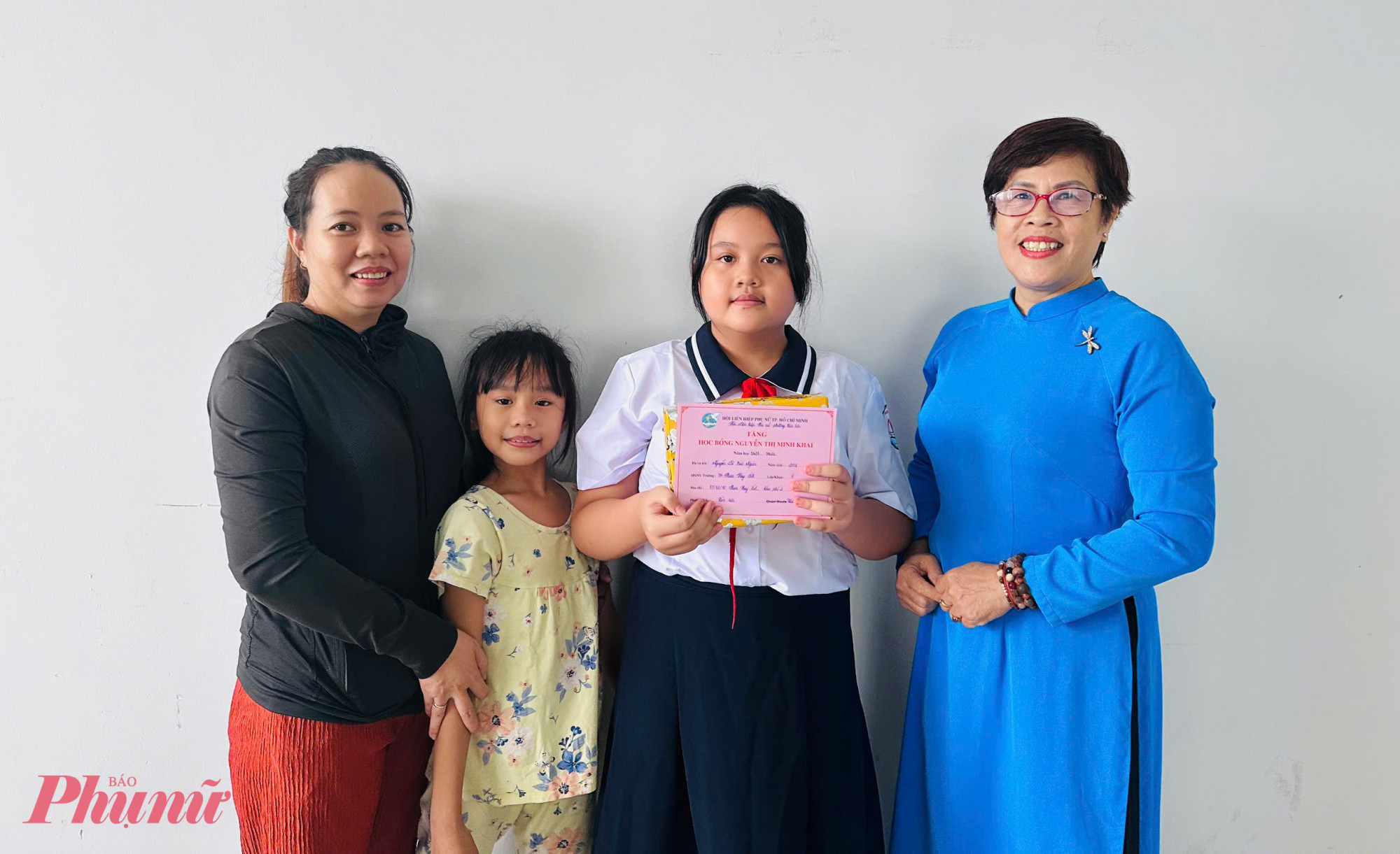 Bé Nguyễn Lê Bảo Ngân (lớp 6, trường THCS Ngô Quyền) cùng mẹ và em gái phấn khởi khi nhận được phần học bổng tiếp sức