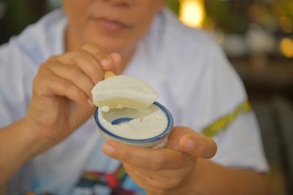Kanom Tuay (bánh chén hấp) có 2 lớp rõ rệt: lớp dưới mềm, hơi trong suốt, ngọt thanh; lớp trên có màu trắng đục, có vị mặn nhẹ và béo của nước cốt dừa. Bánh bán nhiều ở các chợ hoặc đến quán Tam Quốc ở 107 đường Suthon Kosa, khu Khlong Toei.