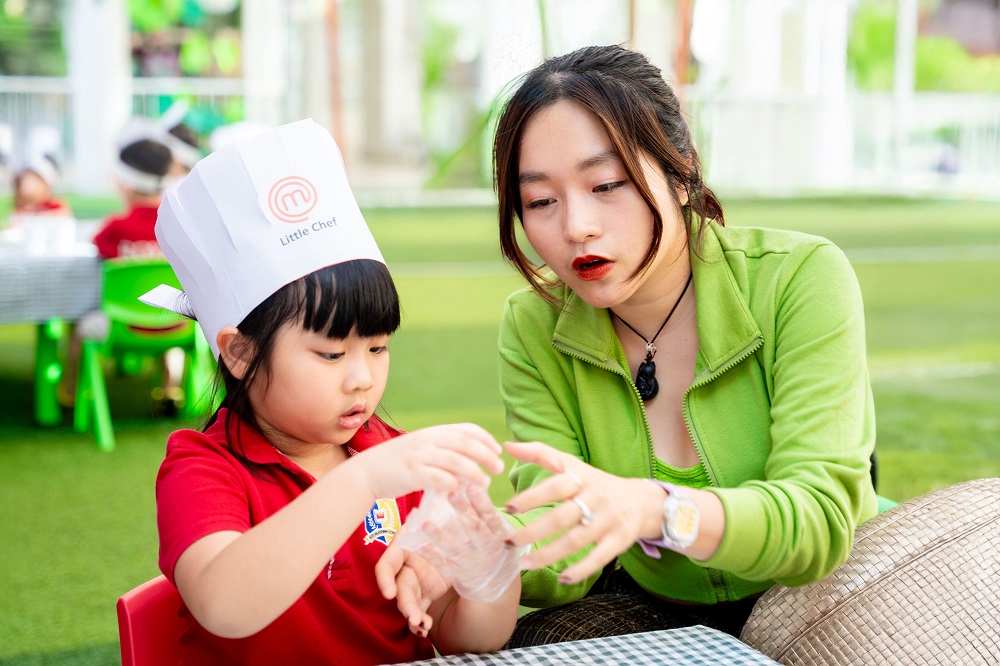 Chị Hoàng Thị Minh Ngọc đồng hành cùng con trong lễ hội “Đầu bếp tí hon” - Ảnh: Royal School