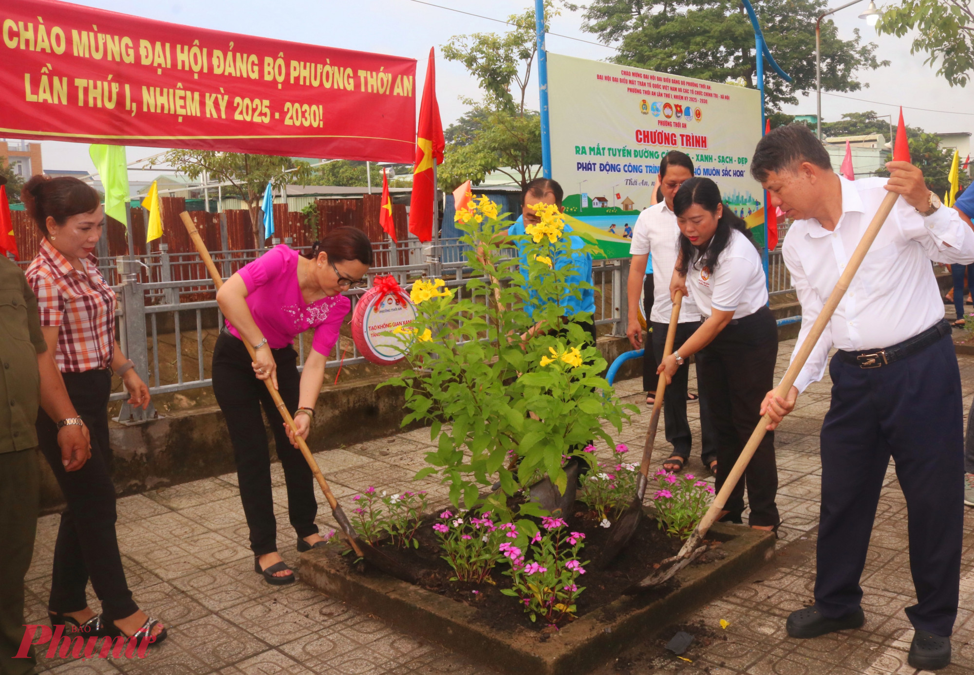 Đại biểu dự chương trình cùng trồng hoa trong các bồn xi măng quanh công viên văn hoá – thể thao bên rạch Tám Giáo - Ảnh: Mẫn Nhi