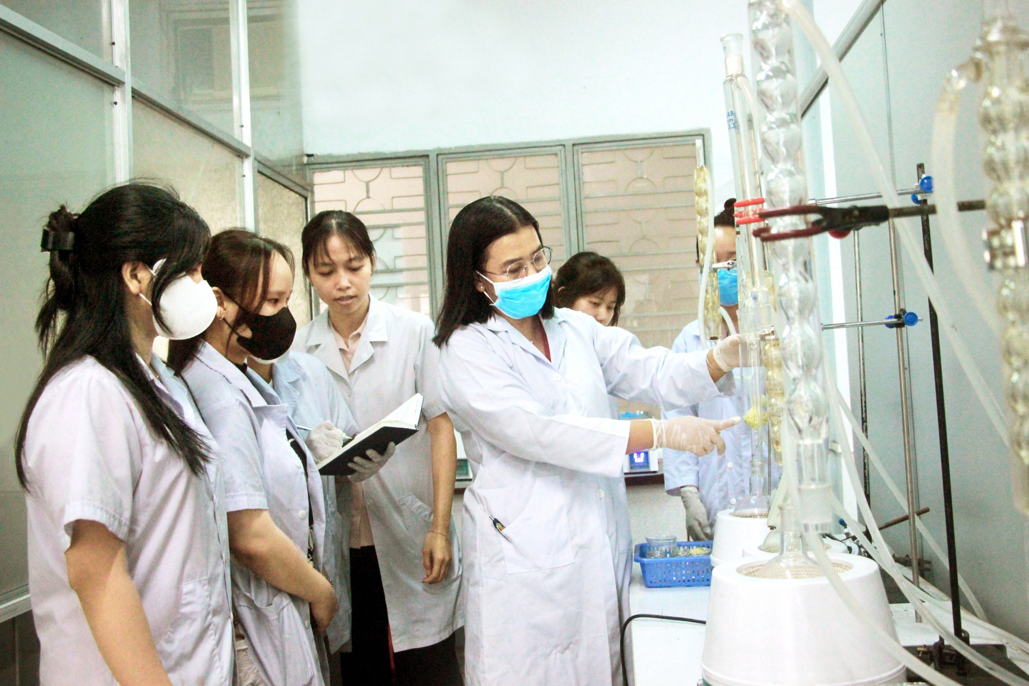 Phó giáo sư, tiến sĩ Mai Huỳnh Cang (đứng hàng đầu) - Trường đại học Nông Lâm TPHCM - hướng dẫn nhóm sinh viên Khoa Công nghệ hóa học và thực phẩm của trường tham gia nghiên cứu khoa học - ẢNH: NGUYỄN LOAN