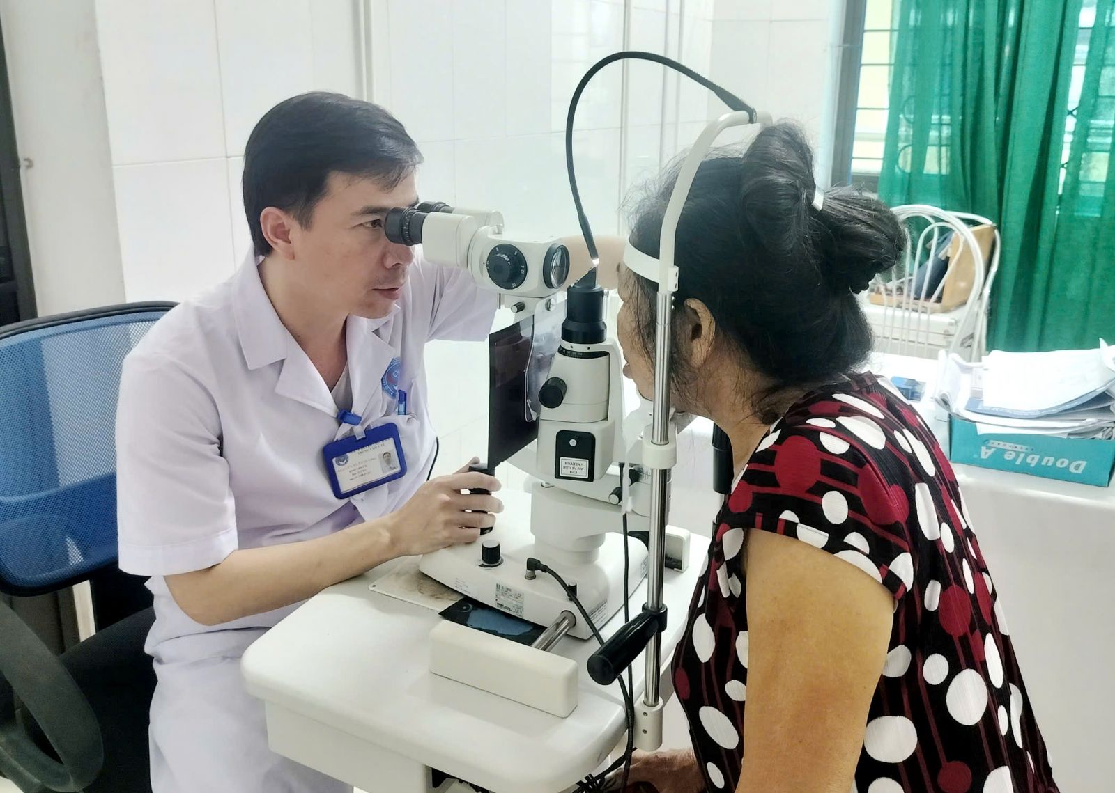 Bác sĩ kiểm tra tình trạng mắt cho bà L. sau 4 ngày điều trị - Ảnh: Nhật Thắng