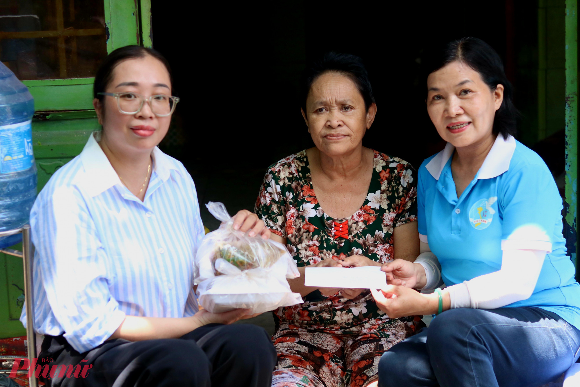 Bà Nguyễn Thị Minh – Phó chủ tịch Hội LHPN phường Thủ Đức, TPHCM (bìa trái) và chị Hoàng Thị Như Thuy – Chi hội trưởng Chi hội Phụ nữ khu phố 23, phường Thủ Đức (bìa phải) – ghé nhà thăm, trao tiền hỗ trợ trong tháng Tám cho bà Lê Thanh Thủy - Ảnh: Thảo Nguyên