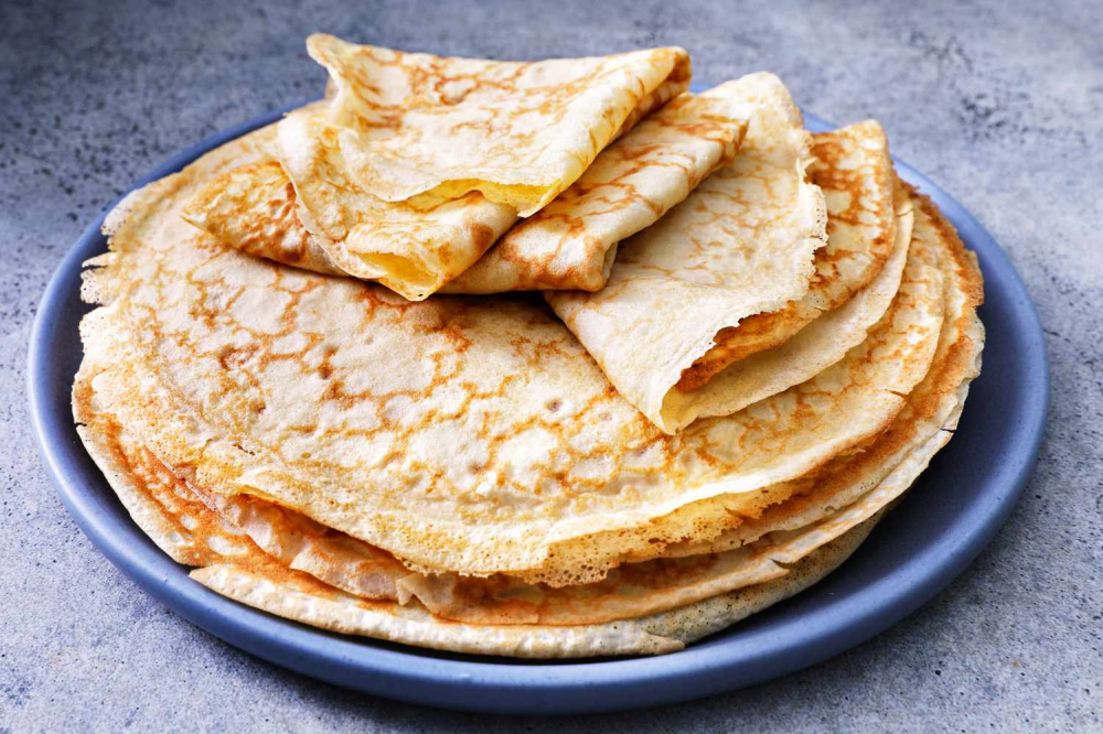 Crepe là món bánh mỏng của Pháp, ăn kèm nhiều loại nhân khác nhau. Đánh đều bột mì, trứng, sữa và một chút muối thành hỗn hợp lỏng. Dùng chảo chống dính, tráng một lớp mỏng để có vỏ crepe vàng nhạt. Nhân bánh có thể là Nutella, mứt trái cây, hoặc chuối thái lát. Gập bánh lại hoặc cuộn tròn, rắc thêm đường bột cho đẹp. Vừa nhẹ nhàng vừa tinh tế, crepe là món ăn vặt cực hợp buổi chiều.