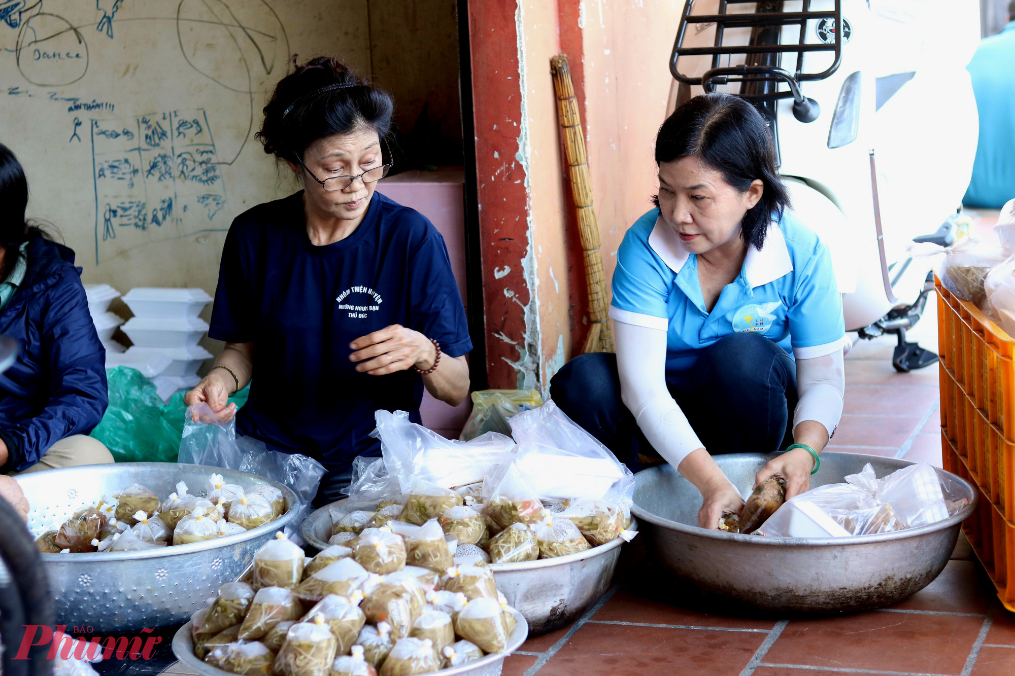 Cán bộ, hội viên phụ nữ khu phố 23, phường Thủ Đức và thành viên nhóm thiện nguyện Những người bạn Thủ Đức tề tựu chuẩn bị những hộp cơm nóng, canh thơm tặng người lao động - Ảnh: Thảo Nguyên