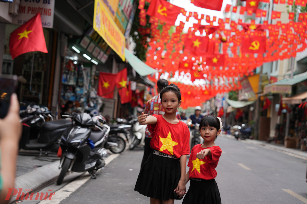 Tiếng cười trẻ thơ vang lên rộn ràng giữa sắc cờ rực rỡ, tạo nên khung cảnh ấm áp.