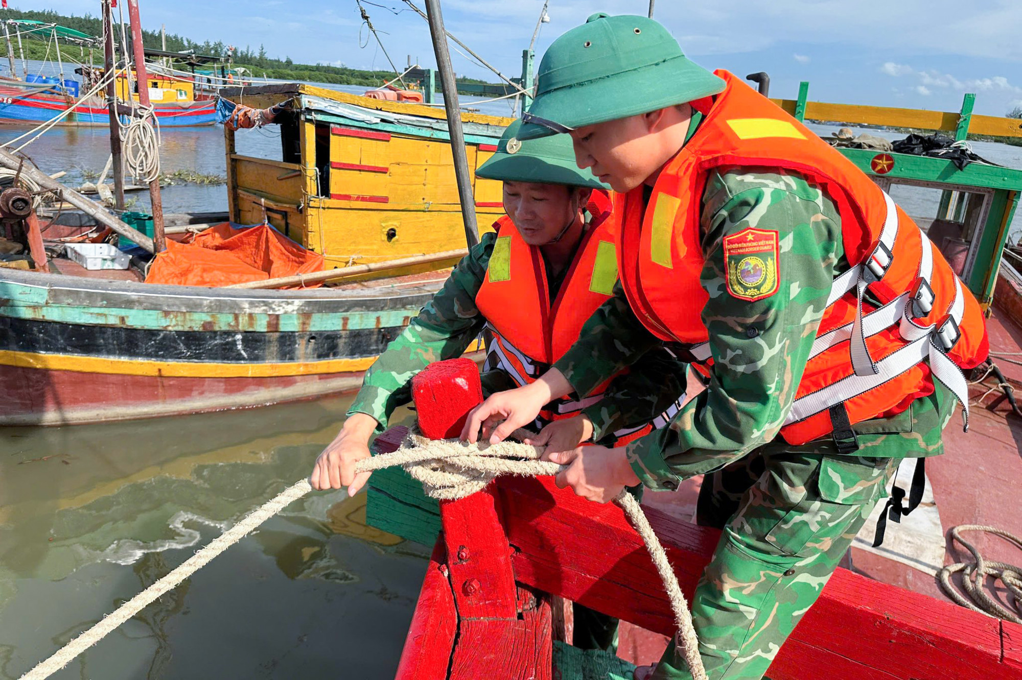 Bộ đội biên phòng hỗ trợ ngư dân neo đậu tàu thuyền - Ảnh: Hải Thượng