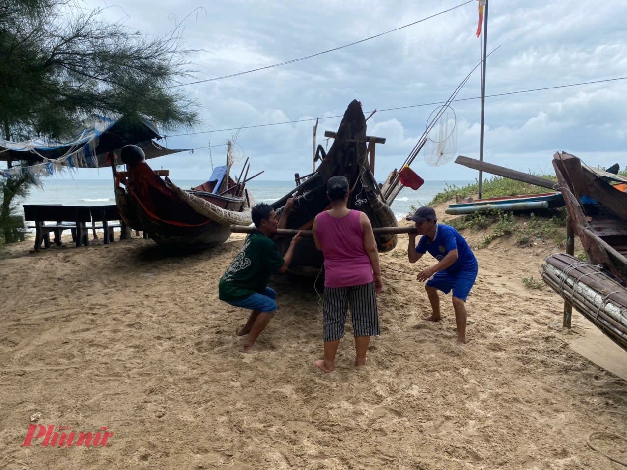 Người dân phường Thuận An giúp nhau đưa thuyền lên bờ tránh bão