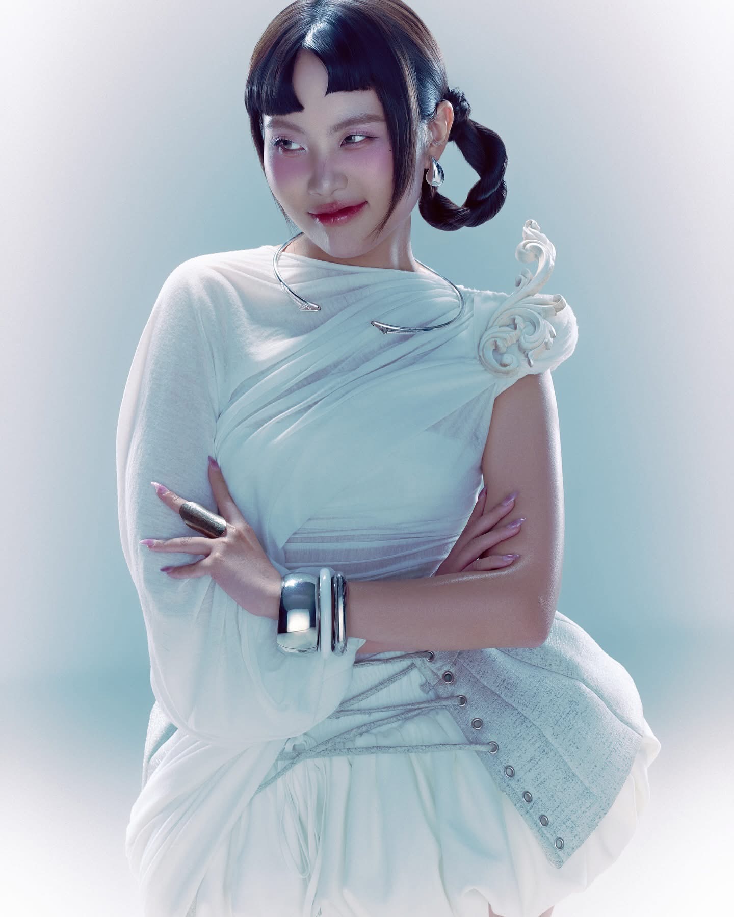 Phương Mỹ Chi mang đến một phong cách tương lai pha cổ điển futuristic - retro với cách trang điểm và tạo hình đầy sáng tạo. Lớp nền được xử lý căng bóng, má hồng được tạo điểm nhấn bằng hiệu ứng tựa như búp bê phá cách. Đôi mắt nhẹ nhàng, không kẻ eyeliner quá sắc để giữ cho ánh nhìn trong trẻo. Đôi môi phủ son bóng hồng đào, tạo cảm giác căng mọng tự nhiên, phù hợp với xu hướng ''glossy lips'' hiện đại.