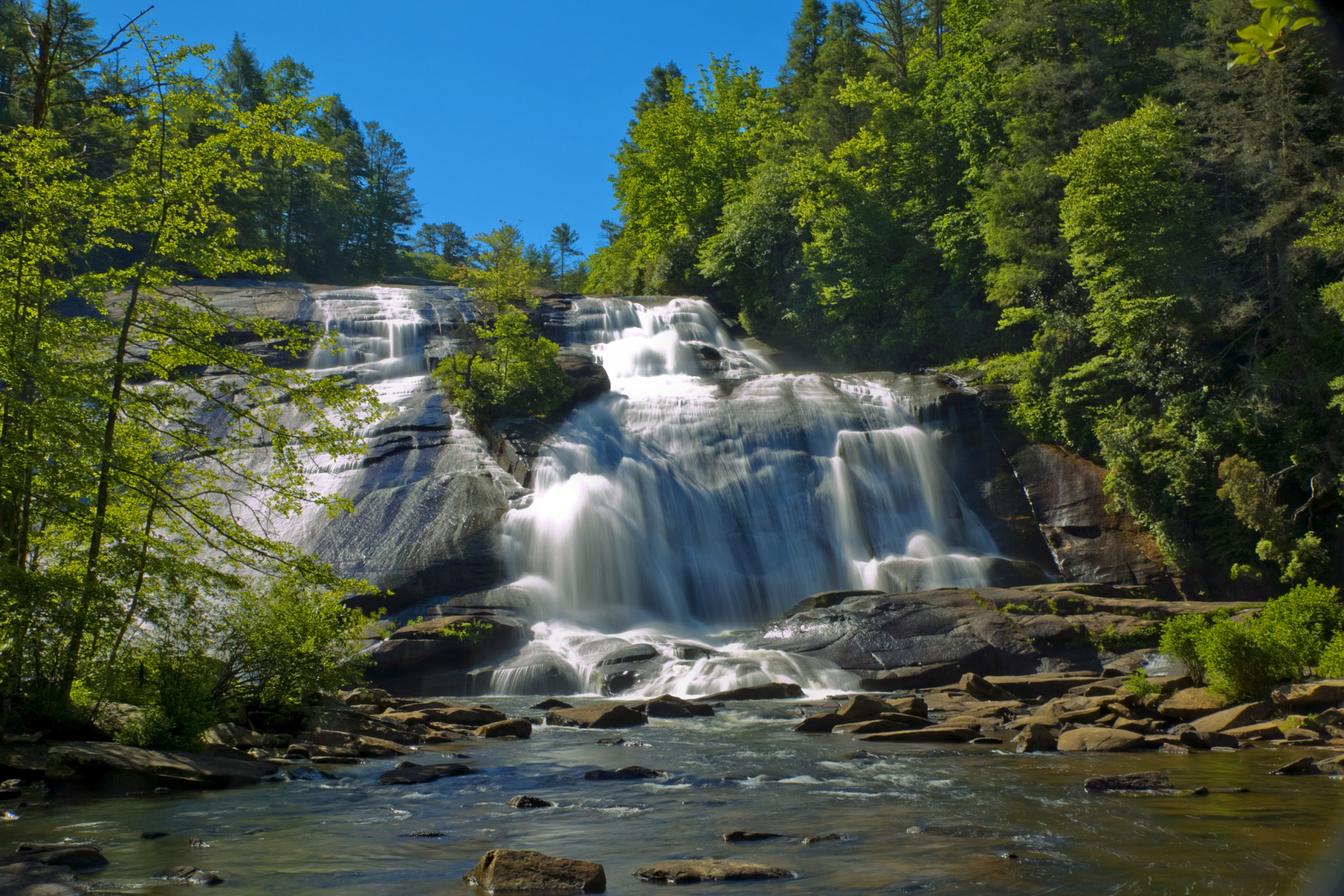 Đường sắt Great Smoky Mountains Được mệnh danh là một trong những chuyến tàu ngắm cảnh ngoạn mục nhất nước Mỹ, Great Smoky Mountains Railroad đưa du khách lạc vào bức tranh thiên nhiên sống động của North Carolina. Trên hành trình, khung cảnh thay đổi liên tục như những tấm bưu thiếp: từ vẻ hùng vĩ của Vườn quốc gia Great Smoky Mountains, sự yên bình của Rừng quốc gia Nantahala, cho đến mặt nước xanh ngắt của Hồ Fontana. Không chỉ có thiên nhiên, chuyến tàu còn đưa bạn ngang qua nhiều công trình lịch sử mang tính biểu tượng, giúp hành trình trở nên vừa nên thơ vừa đậm chất khám phá.