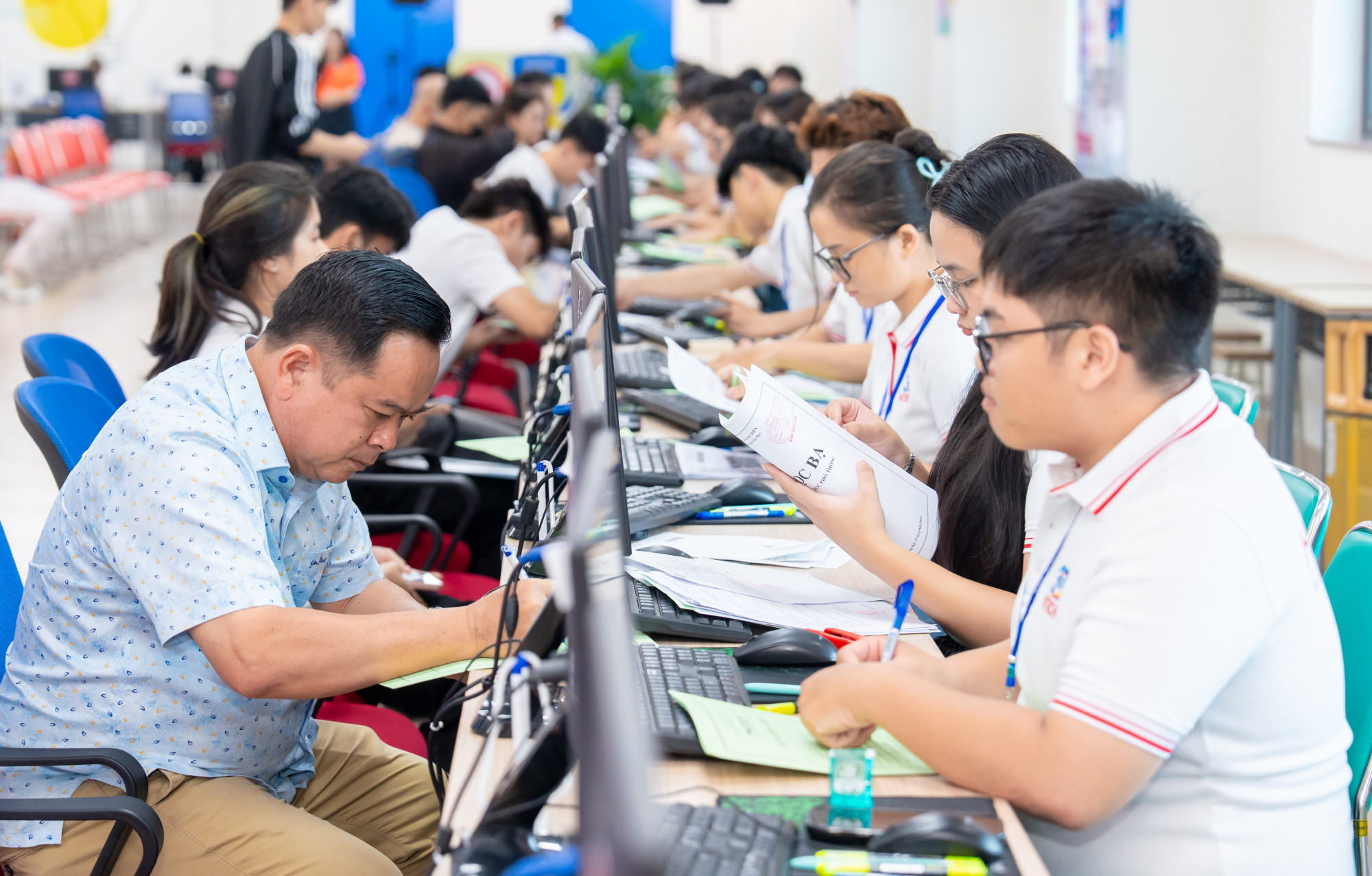 Tân sinh viên, phụ huynh được hướng dẫn làm thủ tục nhập học tại Trường đại học Công nghệ TPHCM sáng nay - Ảnh: N.L