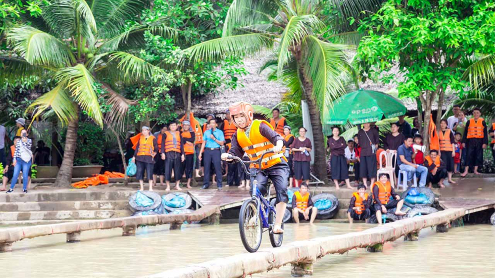 Khu du lịch Lan Vương (Bến Tre) là điểm hẹn lý tưởng cho những ai muốn vui chơi giữa không gian miệt vườn xanh mát. Nơi đây nổi tiếng với các trò chơi dân gian hấp dẫn như đi cầu khỉ, tát mương bắt cá, chèo xuồng, đạp xe qua cầu tre rung lắc. Du khách có thể thỏa sức vui đùa cùng bạn bè, vừa thử thách sự khéo léo vừa ngập tràn tiếng cười.