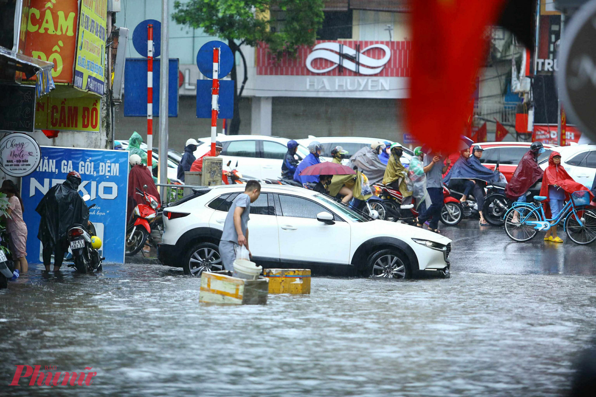 Người dân chắn cảnh báo điểm ngập, hạn chế các phương tiện đi vào vùng nước sâu.