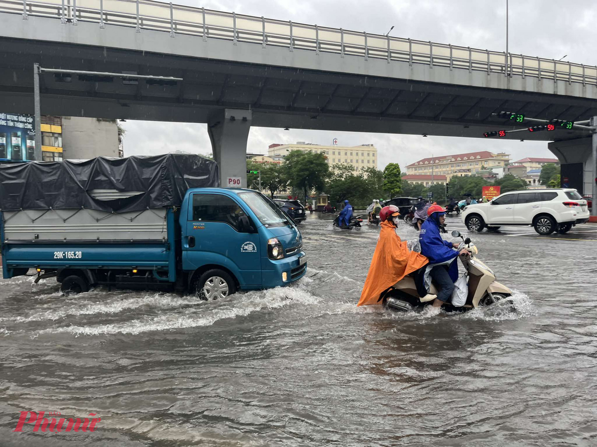 Tại tuyến đường Lê Trọng Tấn - Trường Chinh, người dân bì bõm vượt ngập đi làm.