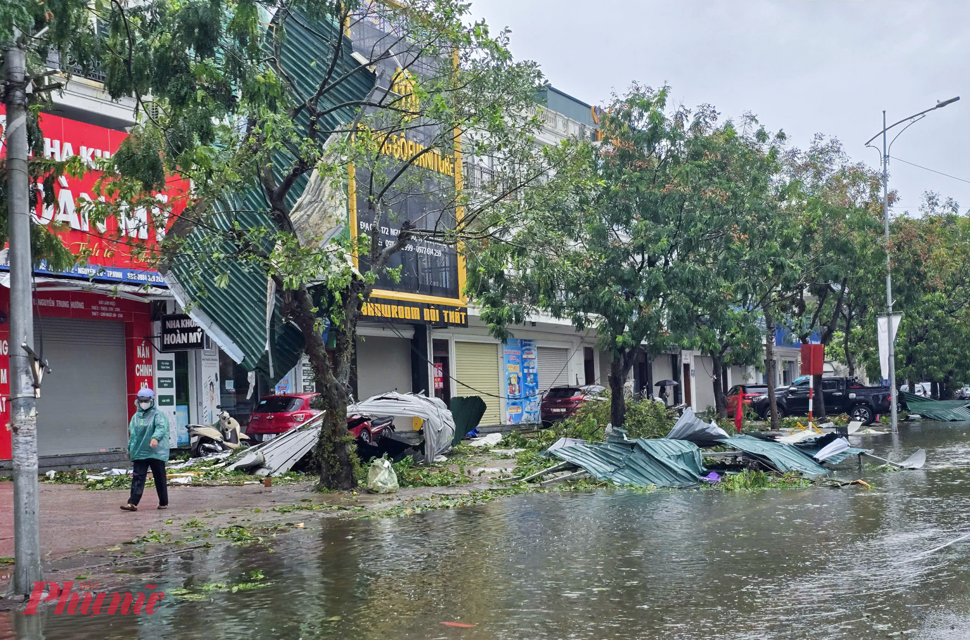 Nhiều mái che bằng tôn ở các cửa hàng, nhà người dân bị gió bão hất tung ra đường.