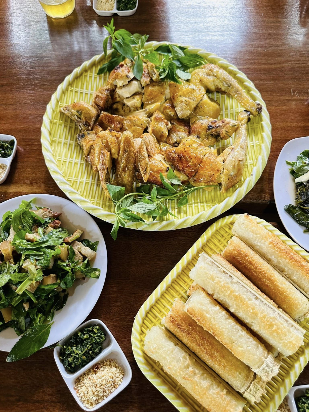 Cơm lam được nấu từ gạo nếp ngon vo sạch, ngâm mềm rồi trộn cùng chút muối và dừa nạo cho vào ống tre, thêm nước suối, dùng lá chuối bịt kín đầu ống, nướng trên bếp than hồng cho chín đều. Gà chín vàng, da giòn nhẹ, thịt thơm. Khi ăn, chấm gà với muối ớt rừng xanh hoặc muối sả, ăn kèm cơm lam - Ảnh: Tất Hòa