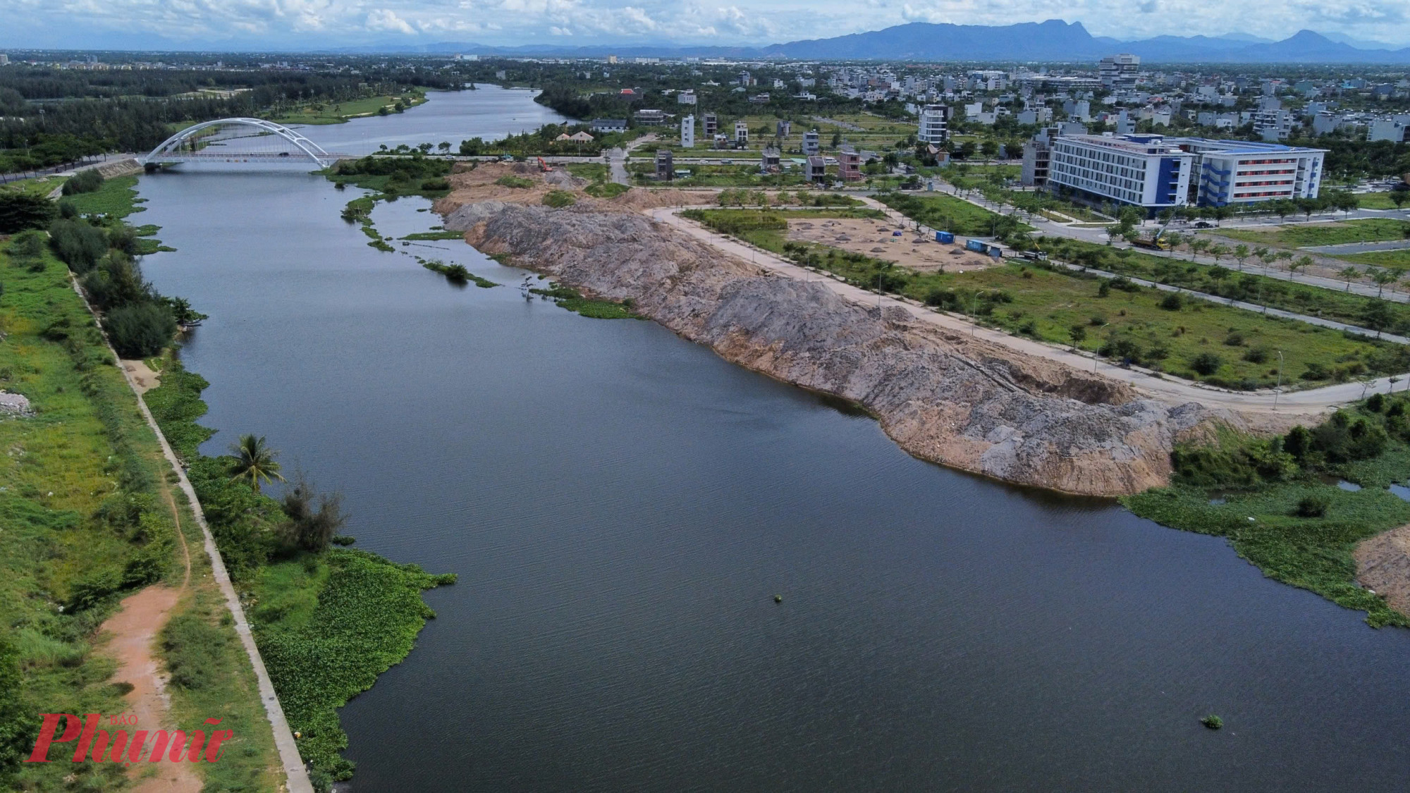 Đoạn sông này từ cầu Bãi Dài đến cầu Cổ Cò đang được tập kết hàng núi đất đá lấn ra mặt nước.