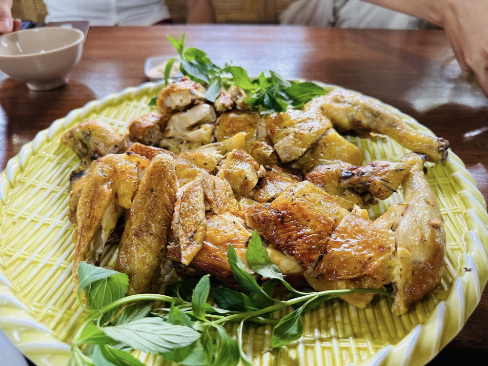 Nhắc đến không thể không nhắc món cơm lam gà nướng trứ danh. Gà nướng là gà thả vườn nặng chỉ khoảng hơn 1kg. Gà được làm sạch, tẩm ướp gia vị bí truyền, nước sả giã lọc và mật ong rừng, rồi nướng trên bếp than. Cơm lam là gạo nếp ngon vo sạch, ngâm mềm rồi trộn cùng chút muối và dừa nạo cho vào ống tre, thêm nước suối, dùng lá chuối bịt kín đầu ống, nướng trên bếp than hồng cho chín đều. Gà chín vàng, da giòn nhẹ, thịt thơm. Khi ăn, chấm gà với muối ớt rừng xanh hoặc muối sả, ăn kèm cơm lam - Ảnh: Tất Hòa