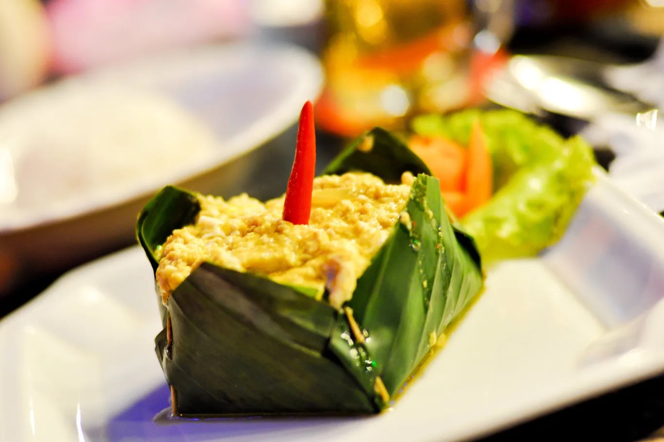 Cá amok là món ăn món quốc hồn quốc túy của Campuchia. Cá lóc tươi trộn hỗn hợp gia vị đặc trưng của người Khmer, thêm với nước cốt dừa và trứng. Sau đó gói trong lá chuối hấp lên tạo ra món ăn mềm, mịn, béo ngậy và thơm nồng. Món này ăn kèm với cơm trắng nóng - Ảnh: Praveen/Flickr