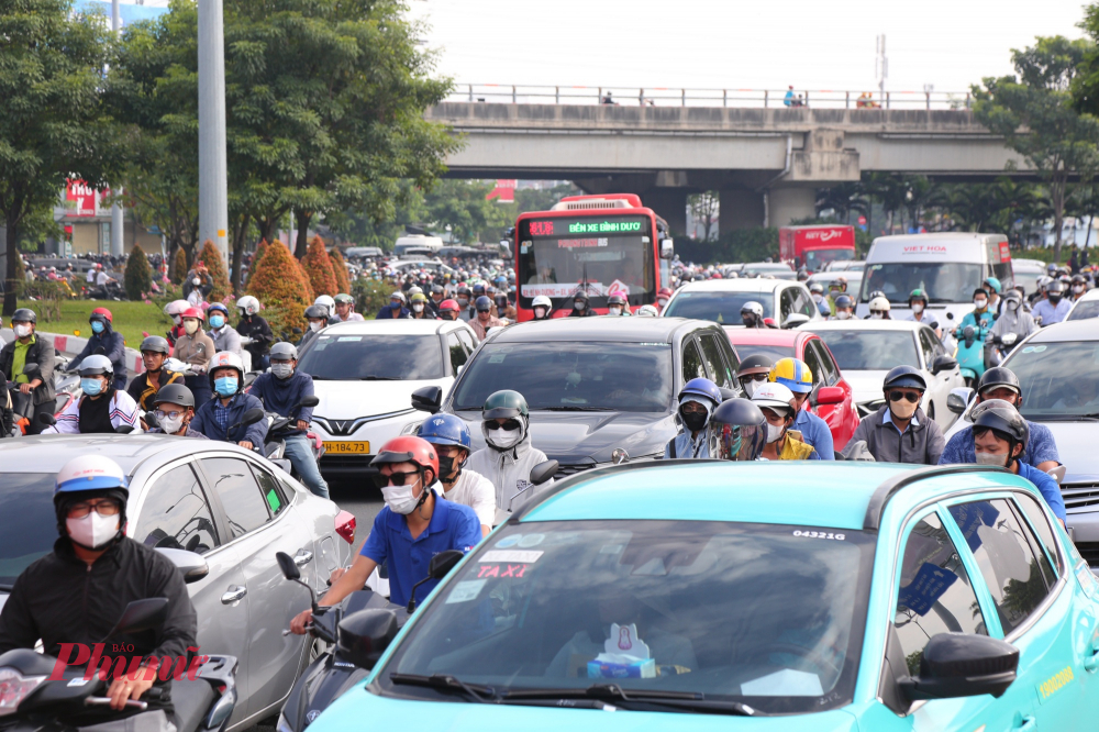 Xe máy len lõi giữa ô tô bao quanh vì kẹt xe ngay chân cầu Bình Triệu 2.